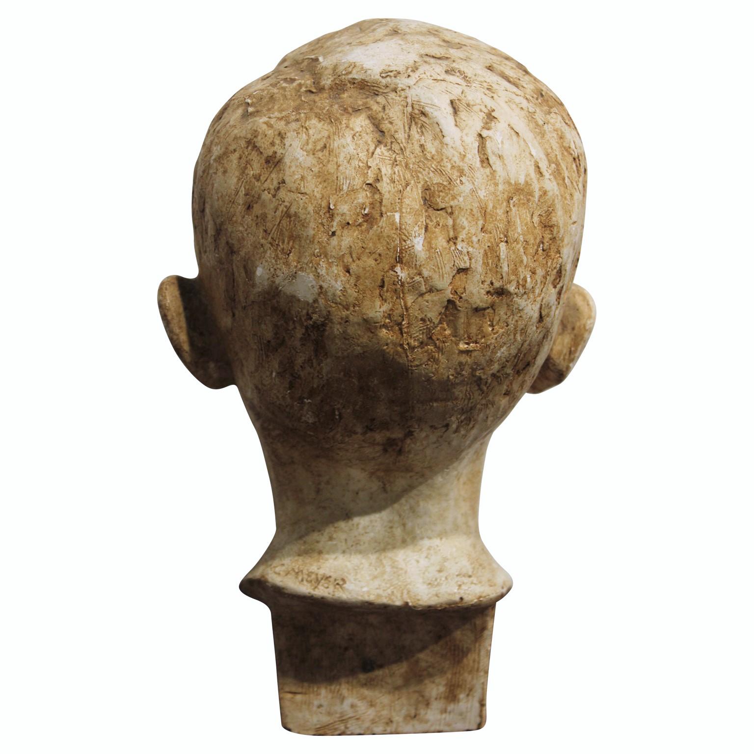 Ceramic sculpture of a young boy with a light tan finish. Signed on the back by C. Meyer. 