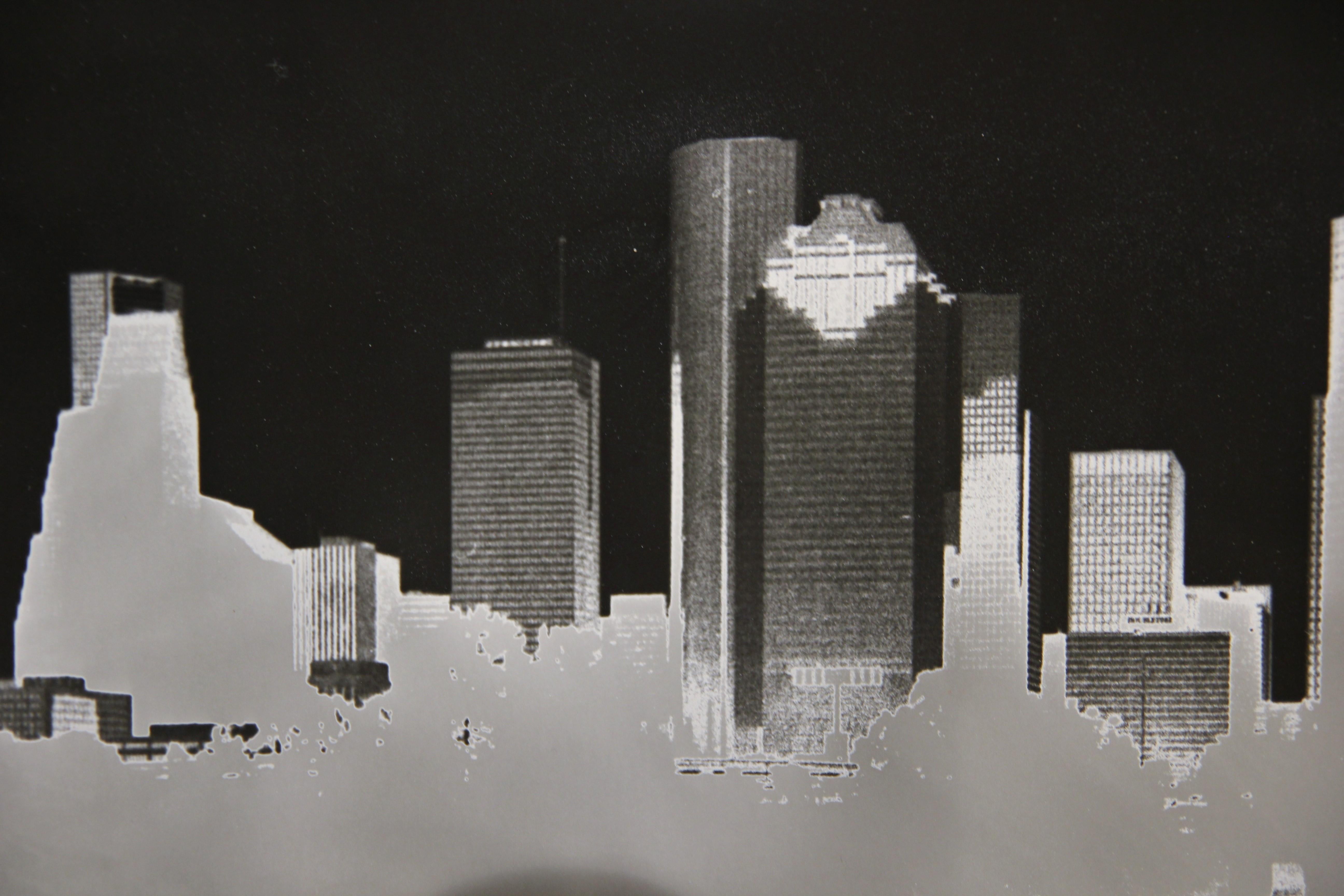 This photograph is a picture of the Houston skyline with a mirrored image of the skyline below. This photograph showcases the Sabbttier process or the results of solarization. The photograph is not framed.

Artist Biography: Pat Truax is a Texas