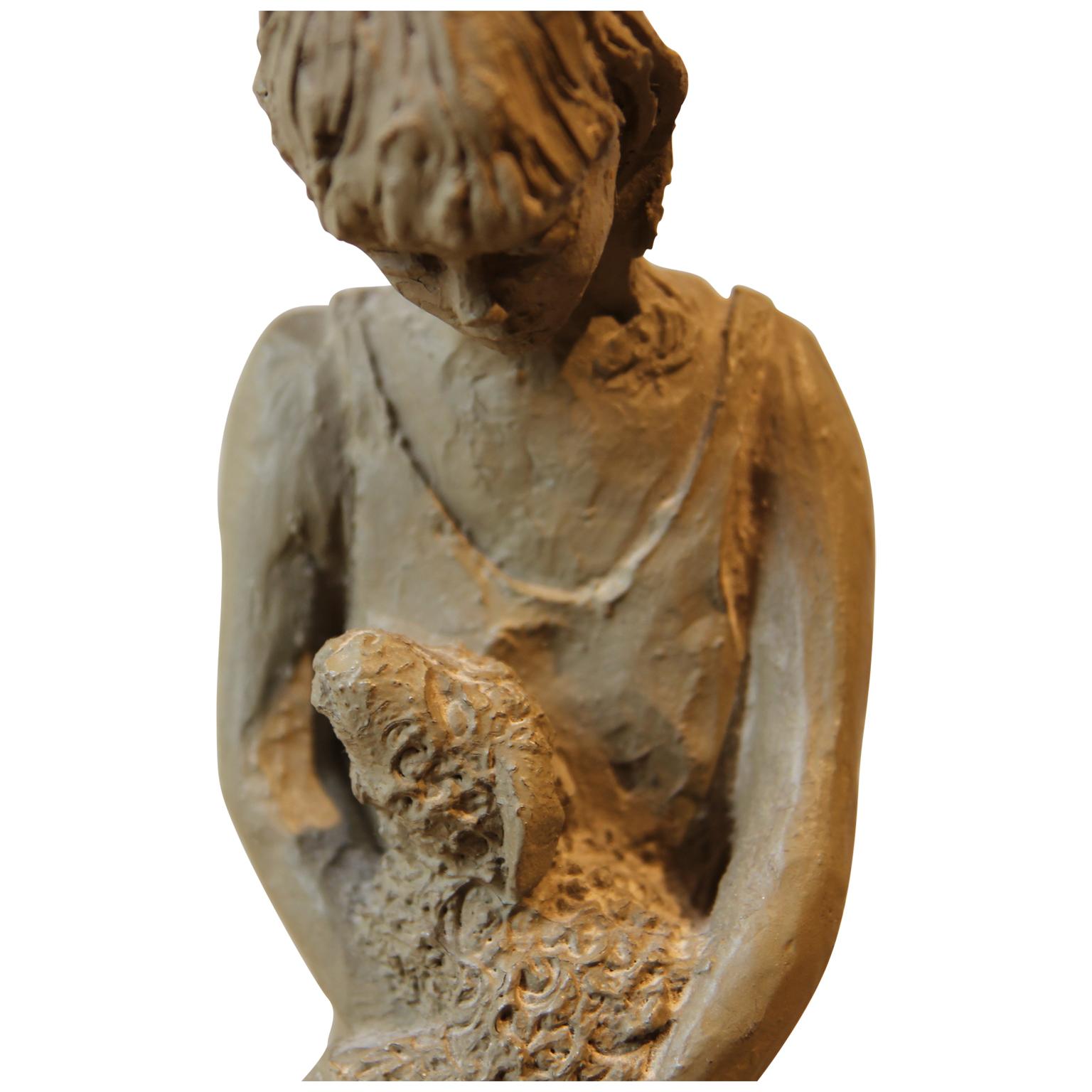 Naturalistic sculpture of a woman standing and holding a small calf. The sculpture is signed 