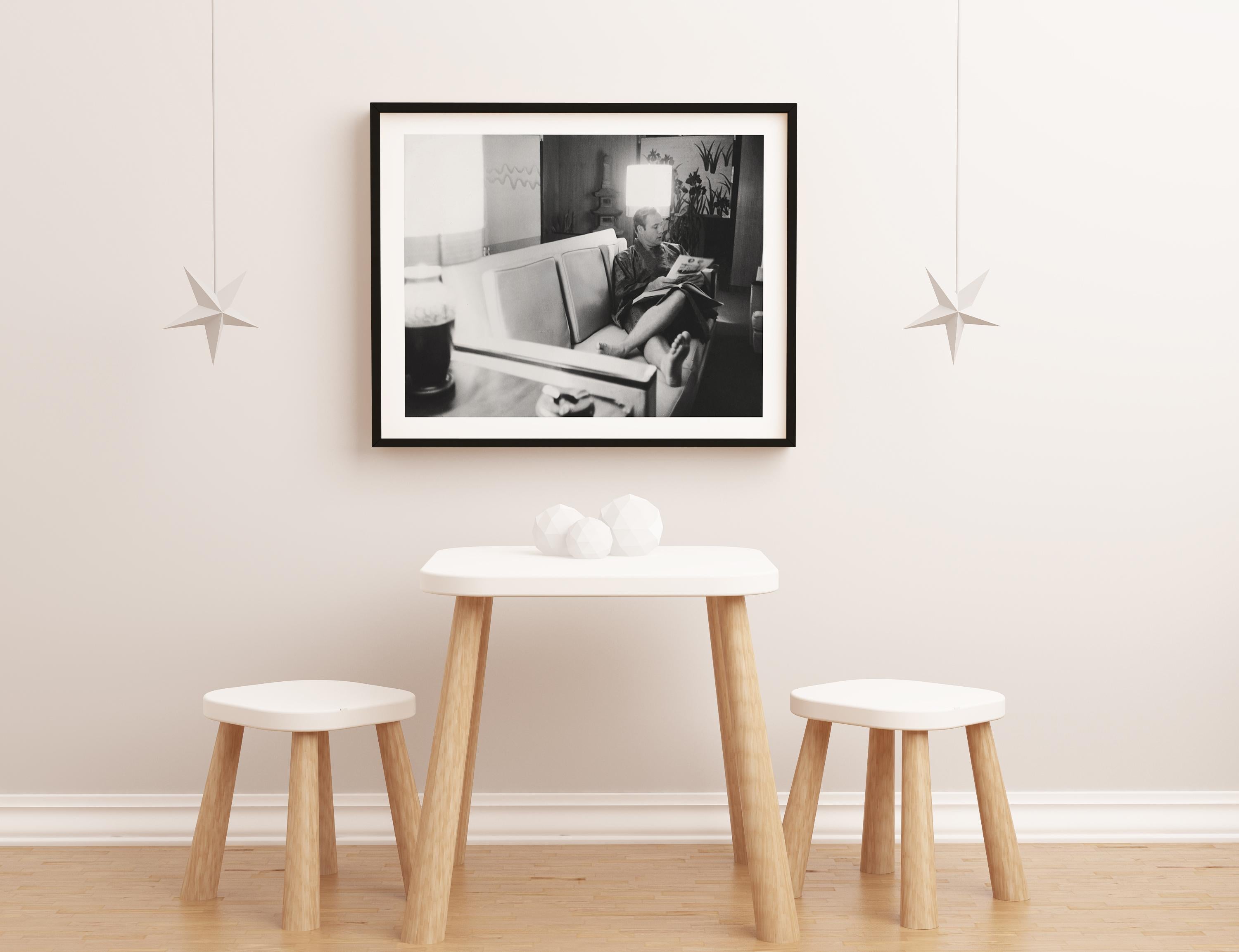 This candid portrait features Marlon Brando relaxing on the couch, reading the newspaper.

Marlon Brando was an American actor and film director. With a career spanning 60 years, he is regarded for his cultural influence on 20th-century film.