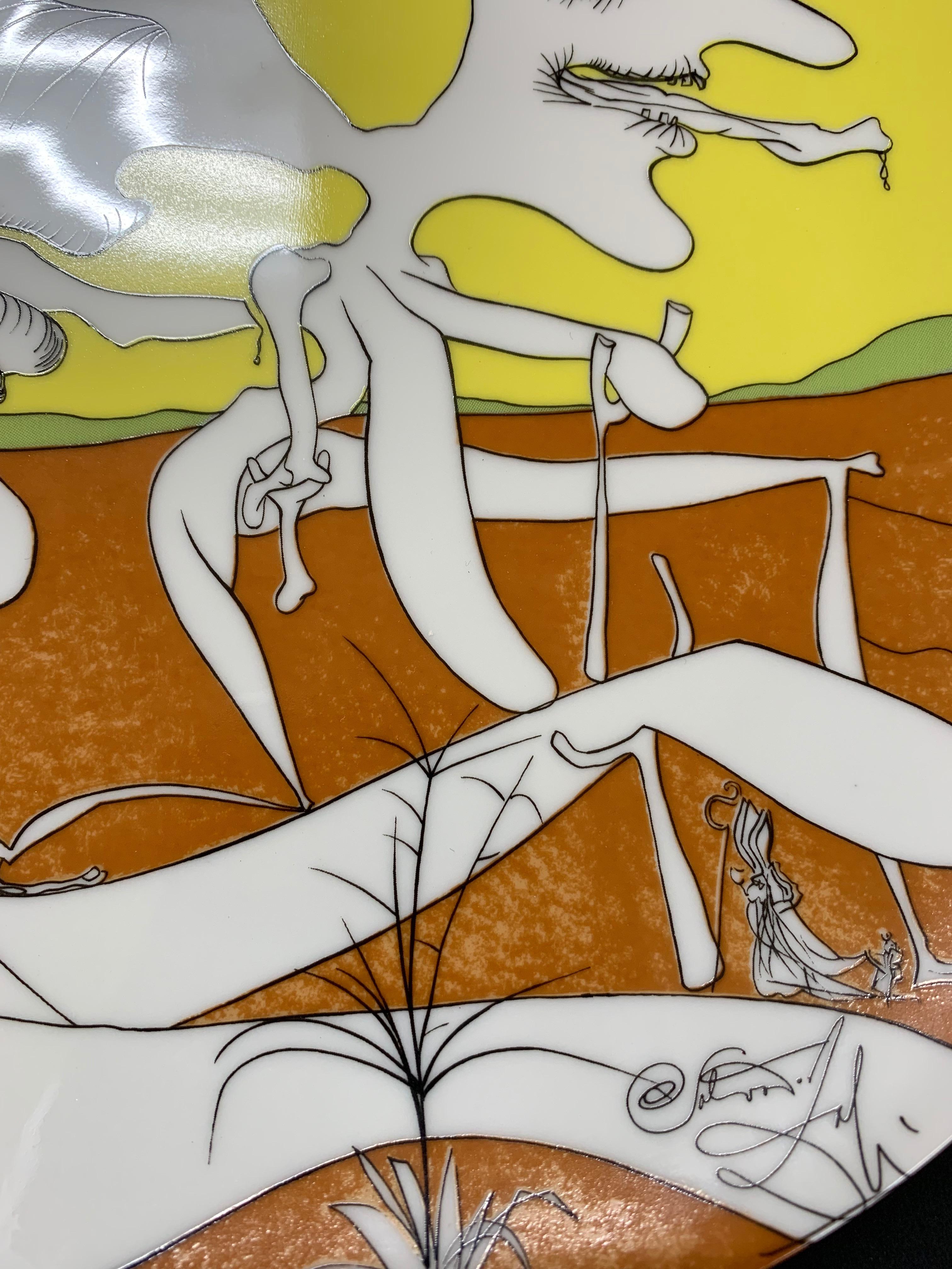 Dieses Stück ist ein authentisches Limoges-Porzellanteller:: das 1974 in Zusammenarbeit mit Salvador Dali angefertigt wurde. Es ist Teil einer Serie von Tellern mit dem Titel „La Conquete du Cosmos“:: die Bilder aus einer gleichnamigen Mappe zeigen.