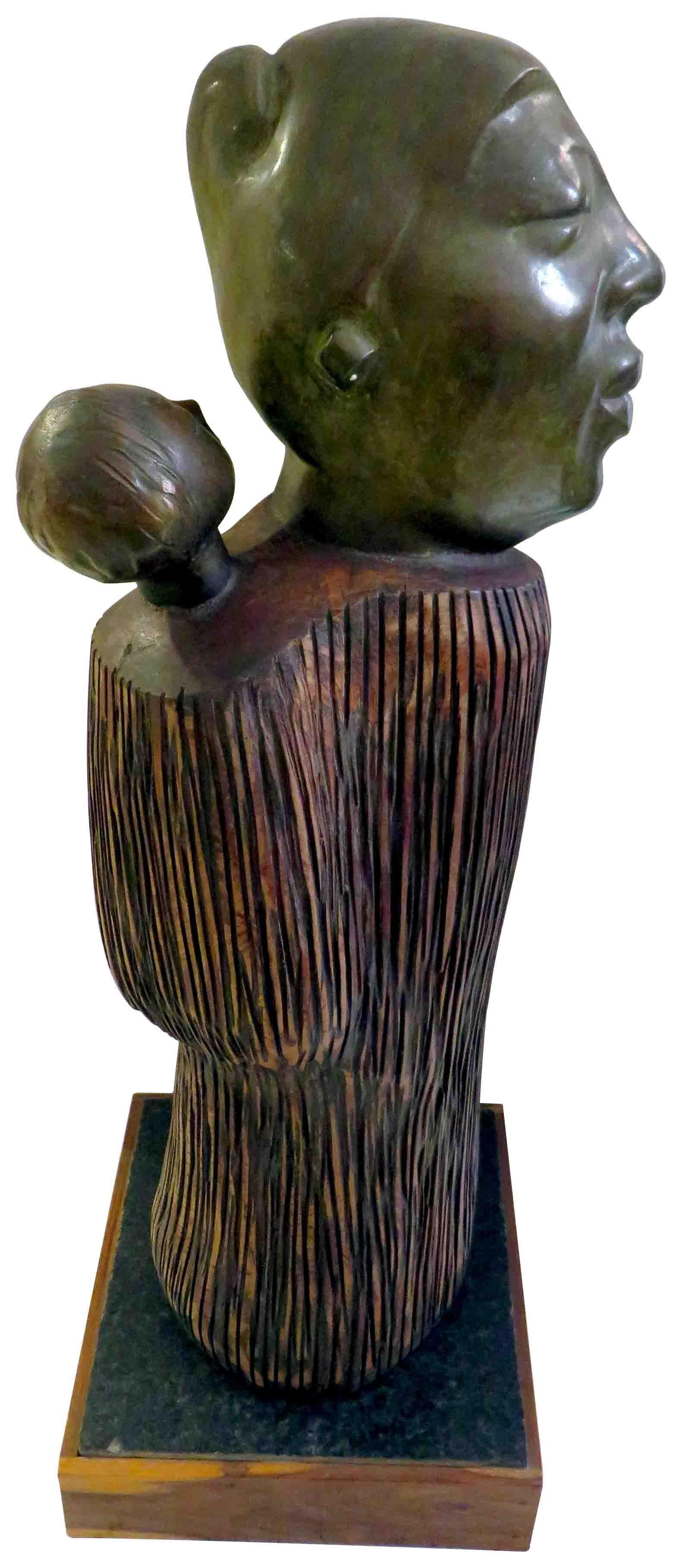 Sunil Kumar Das - A burden I Love to carry - 27 x 11 x 3 inches
Wood & Bronze. Single Edition.

Sunil Kumar Das’s Bronze & Wood also evokes in an innovative formal handling a grave looking tribal mother with her baby snugly pouched on her