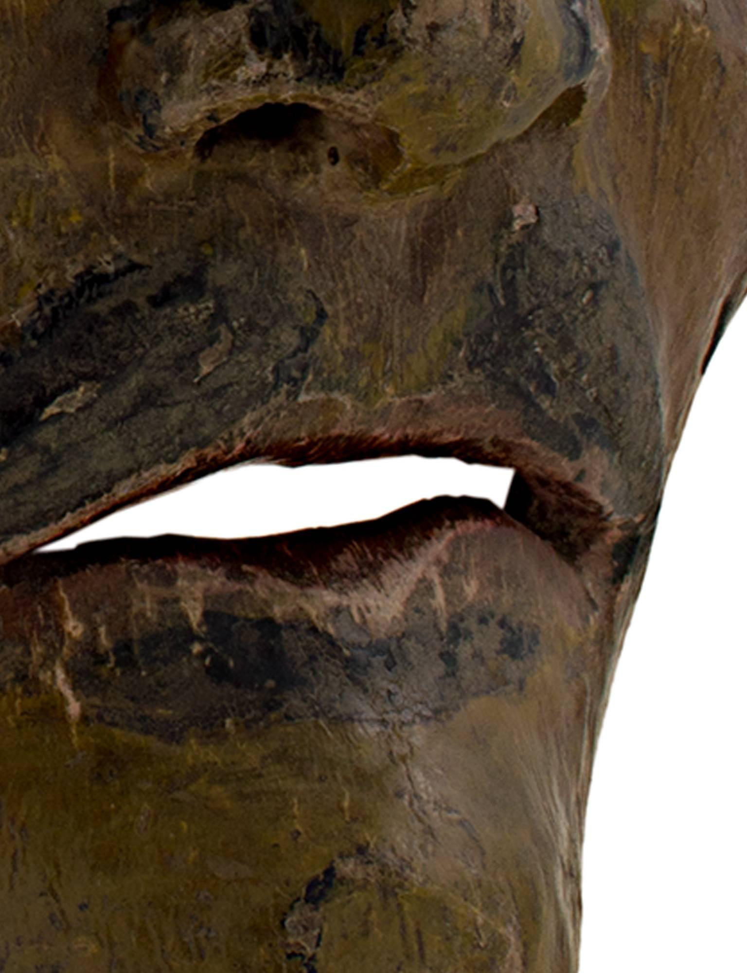 Ce masque, représentant un personnage occidental aux yeux partiellement bridés et à la moustache, a été créé par un artiste indonésien inconnu. Il est d'un vert moutarde profond et mesure environ 7