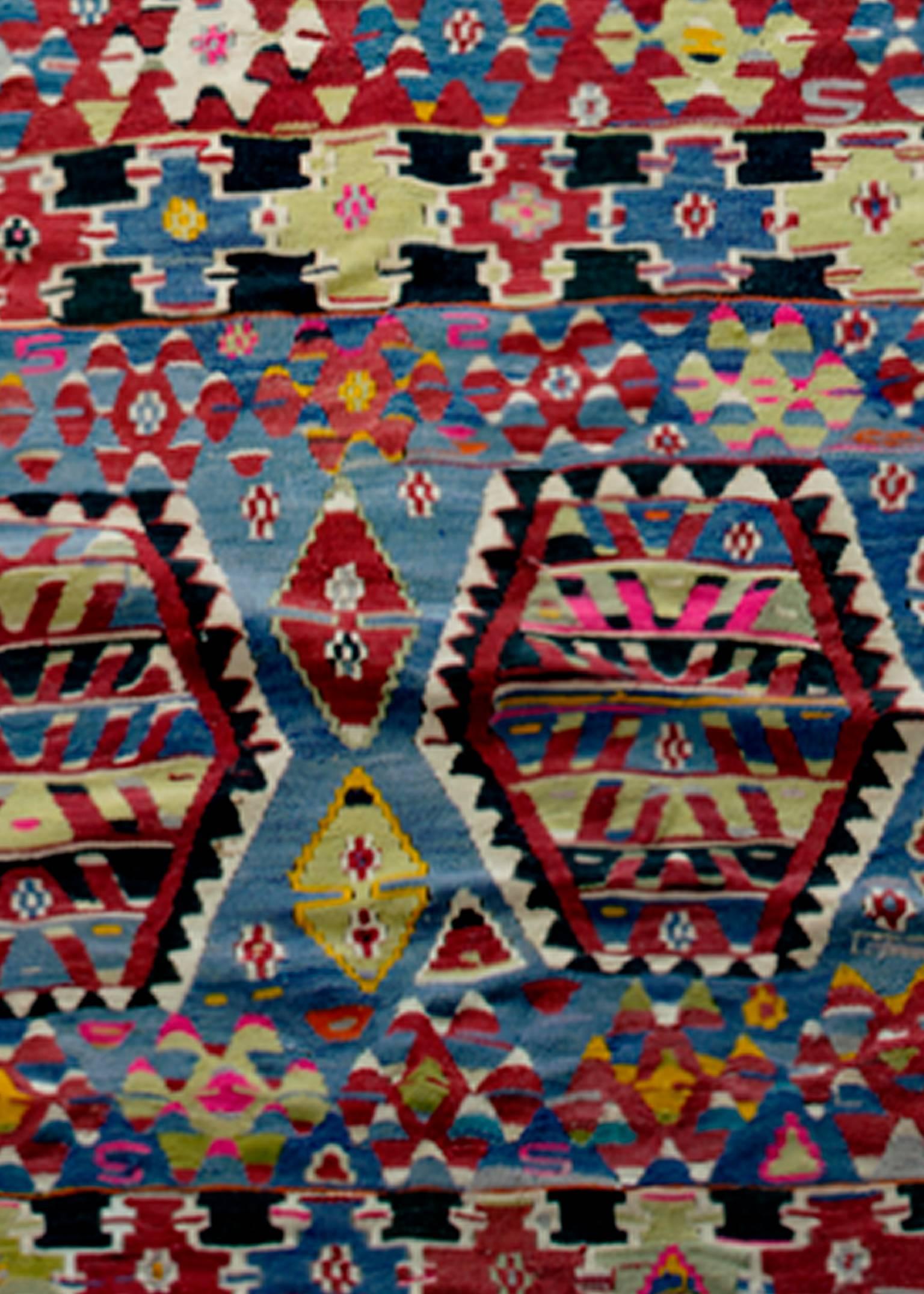 Dieser Kilim-Teppich wurde in der Türkei etwa Mitte des 20. Jahrhunderts aus Wolle handgewebt. Er ist mit geometrischen Mustern in Rot, Schwarz, Blau und Gelb versehen und kostet weniger als 4500 $. Das Design passt perfekt zu jedem Dekor, da es