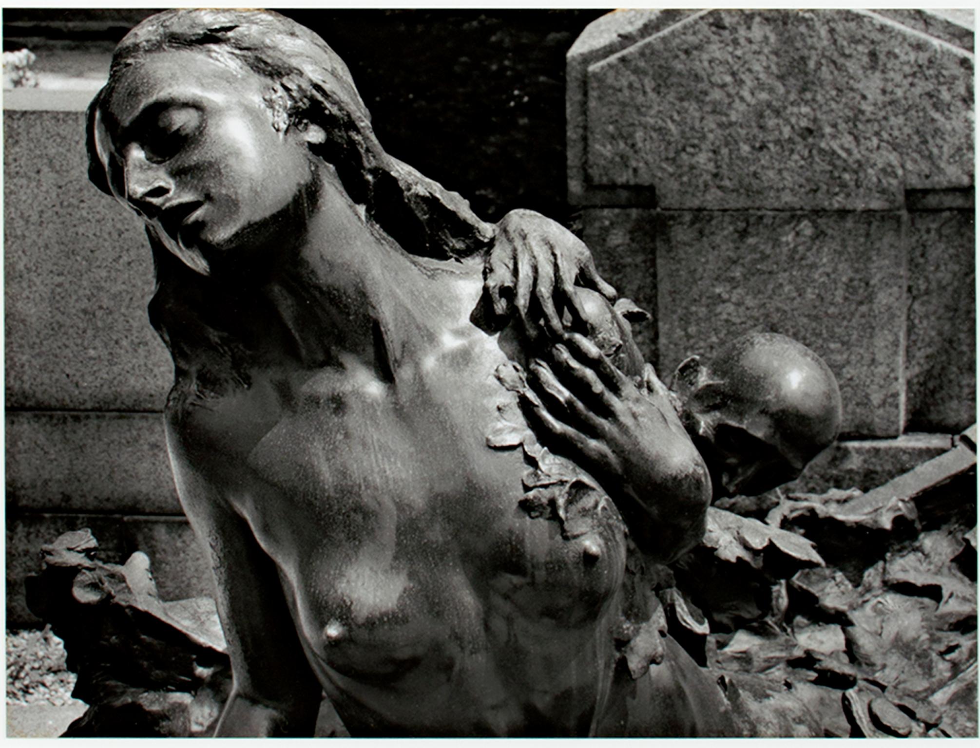 "Milano, Italia" est un tirage photographique original à la gélatine argentique de Philip Krejcarek. L'artiste a signé l'œuvre. Il représente la statue d'une femme nue avec un personnage s'agrippant à son épaule. La photographie est en noir et