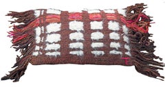 Handwoven pillow with brown, white, orange and pink stripes and fringe