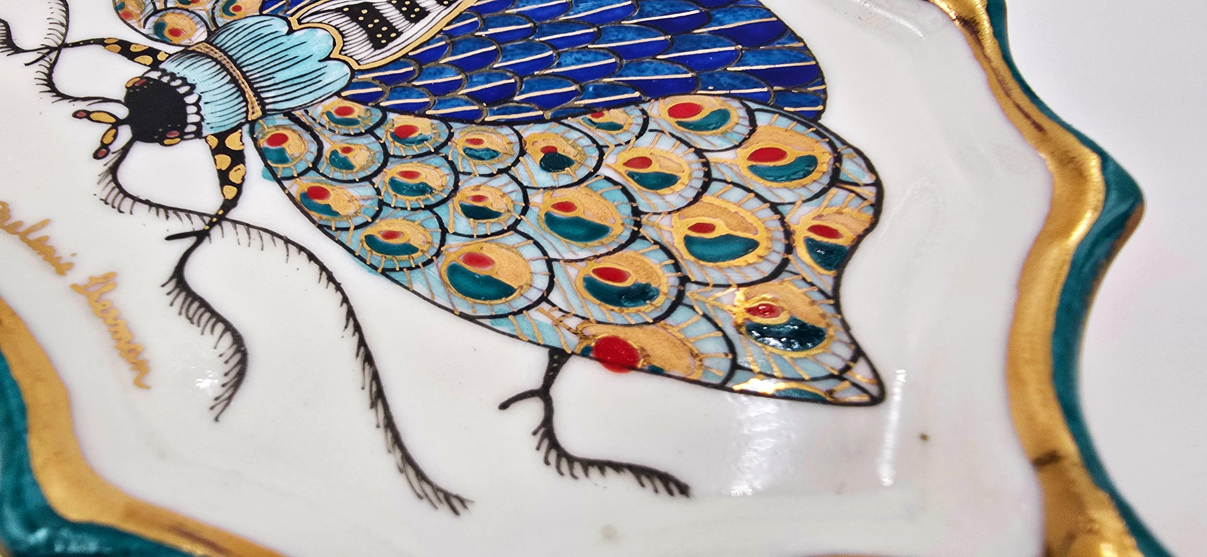 Melanie Sherman
Vintage Moth X (Pièce murale/plat (peint à la main)
Porcelaine, glaçure, surglaçure, peinture au chinois, lustre en or allemand 24k, fil de laiton (pour la suspension, peut être enlevé).
Année : 2025
Taille : 0,5 x 6 x 4,25 pouces