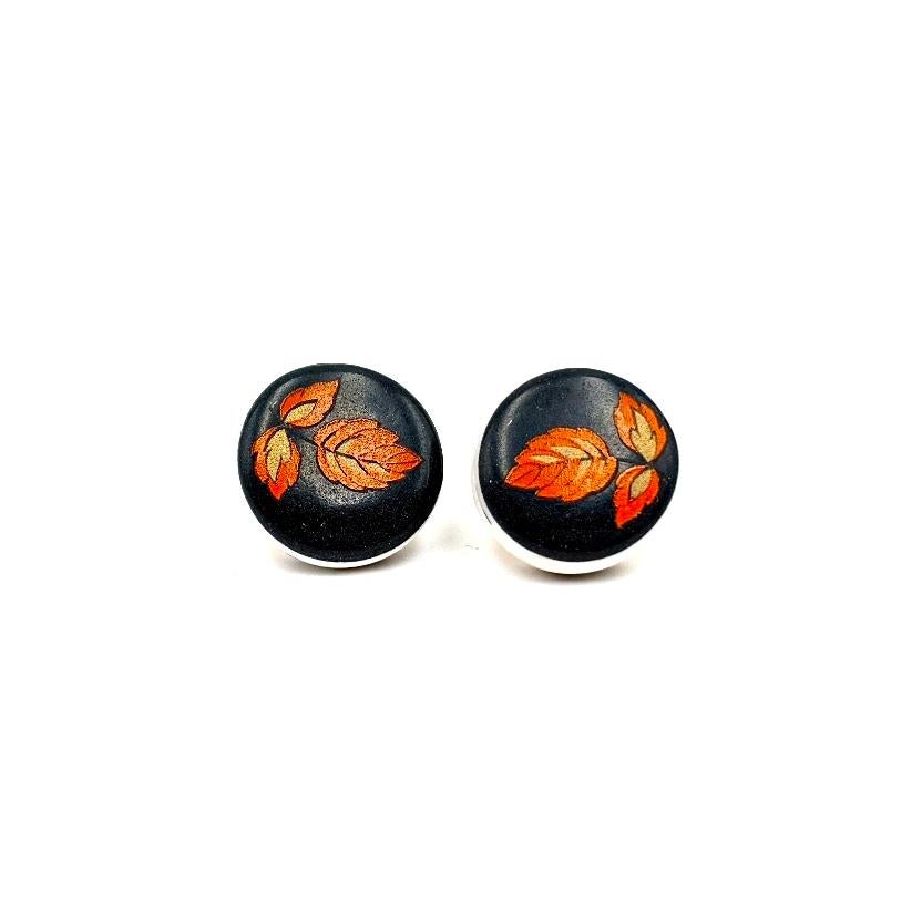 Melanie Sherman
Cufflinks with Red & Gold Flowers on Black Porcelain
Dimensions: 20mm x 17mm x 17mm
Materials: Porcelain, Glaze, Vintage Decal
Metal type: Brass
COA Provided

Melanie Sherman is a ceramic artist, born in Germany and currently