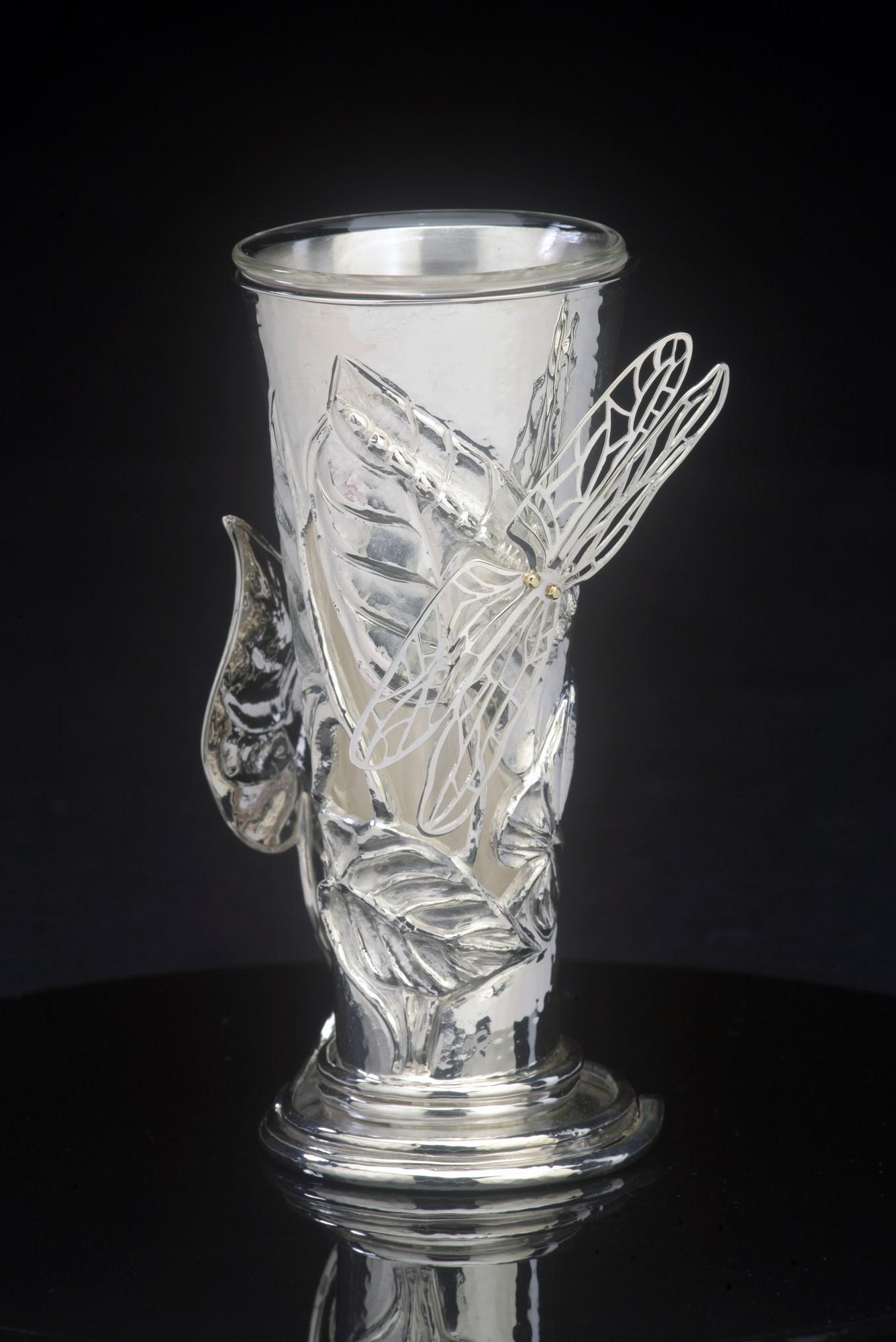 Vase mit Zwiebelblättern und Libellenknospen