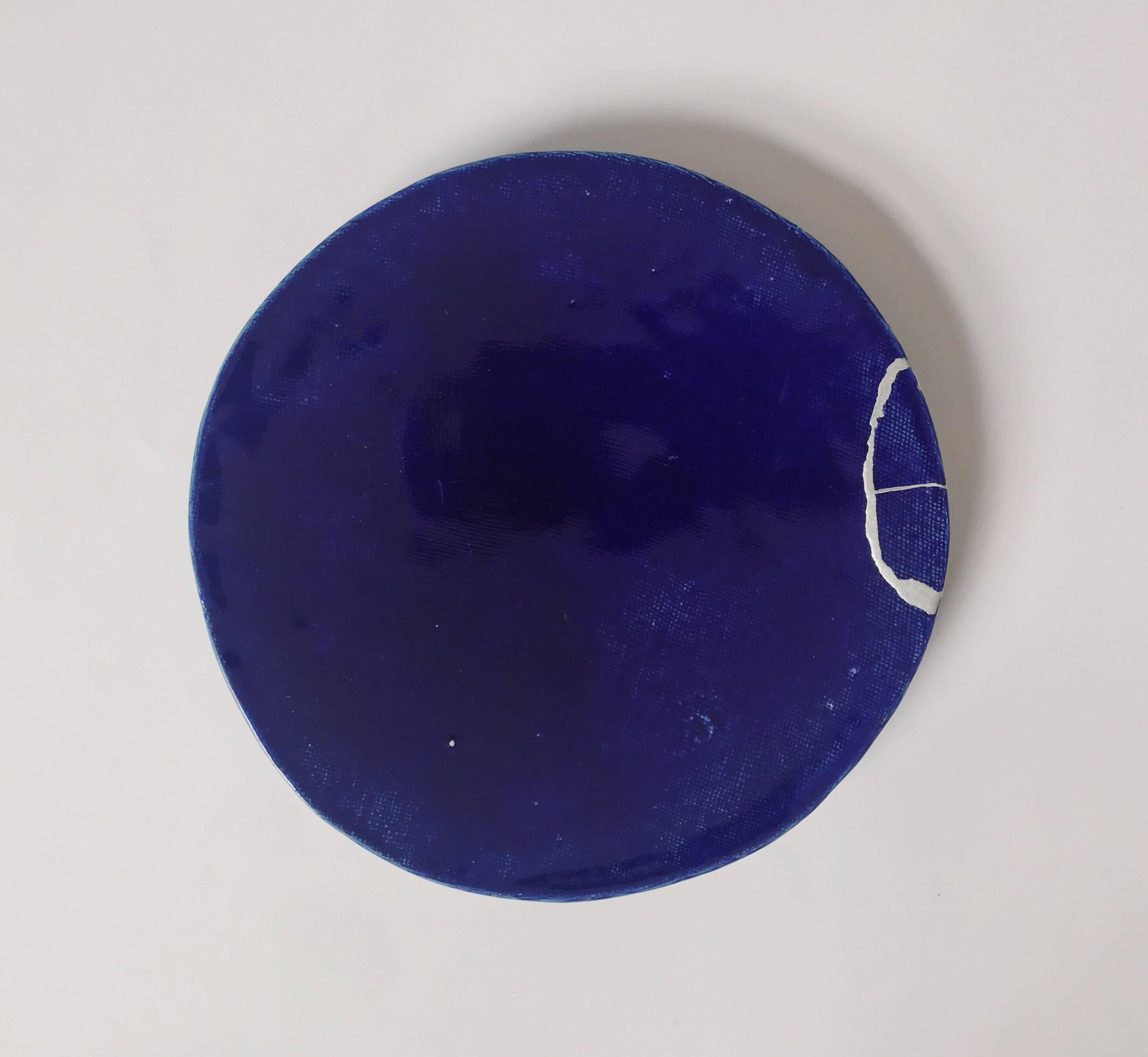 Deep blue ceramic plate from the Sueharu kiln in Konda-Cho, Hyogo Prefecture. Broken and reassembled in the traditional Japanese kintsugi technique by a specialist artisan in Osaka.