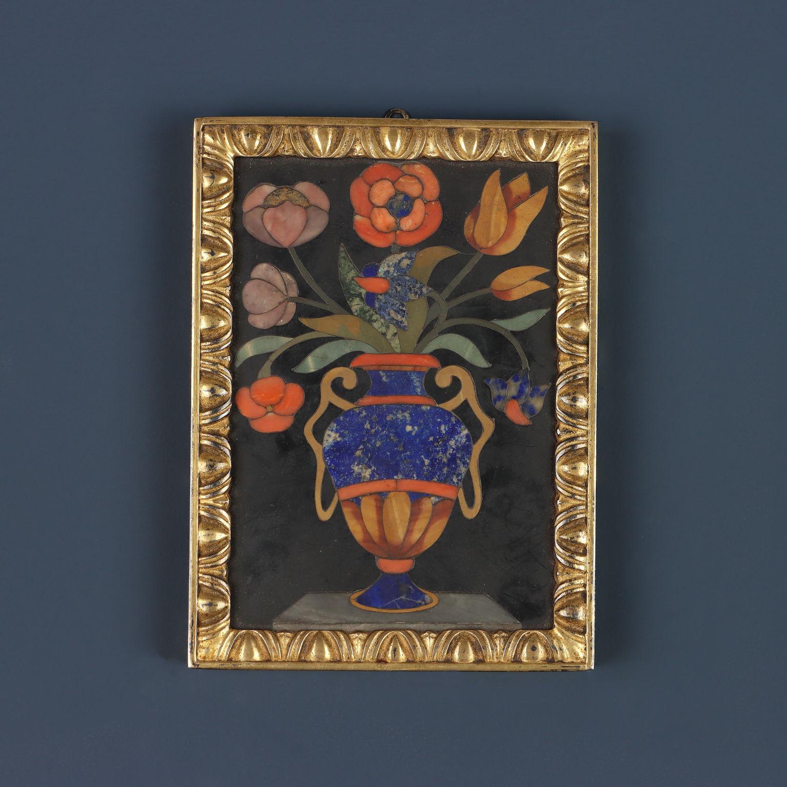 Pair of tiles in clerical stone and rare marble on black comparison ground. On a shelf of gray marble rest two similarly shaped bi-anodized Medici vases in which two floral arrangements of different species are placed. The two commesso paintings are