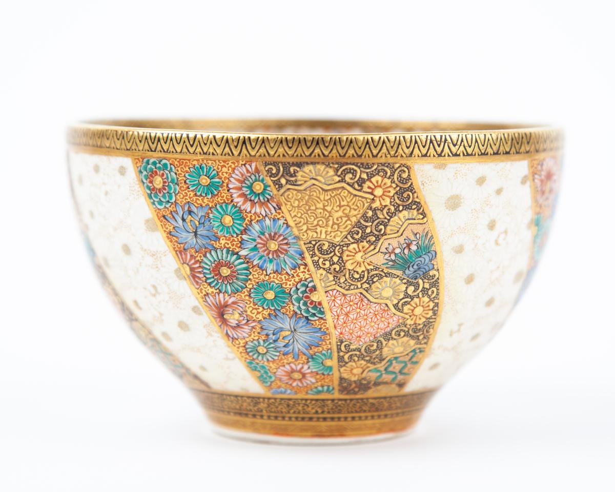 Artist: Kozan Zo
Title: Satsuma tea bowl
Date: Early 20th century
Dimensions: (W)12.2 (D) 12.2 (D) 8 cm
Condition: Wear consistent with age and use. Some gilt loss on signature seal.

A tea bowl painted with chrysanthemums, stylised flowers and 'a