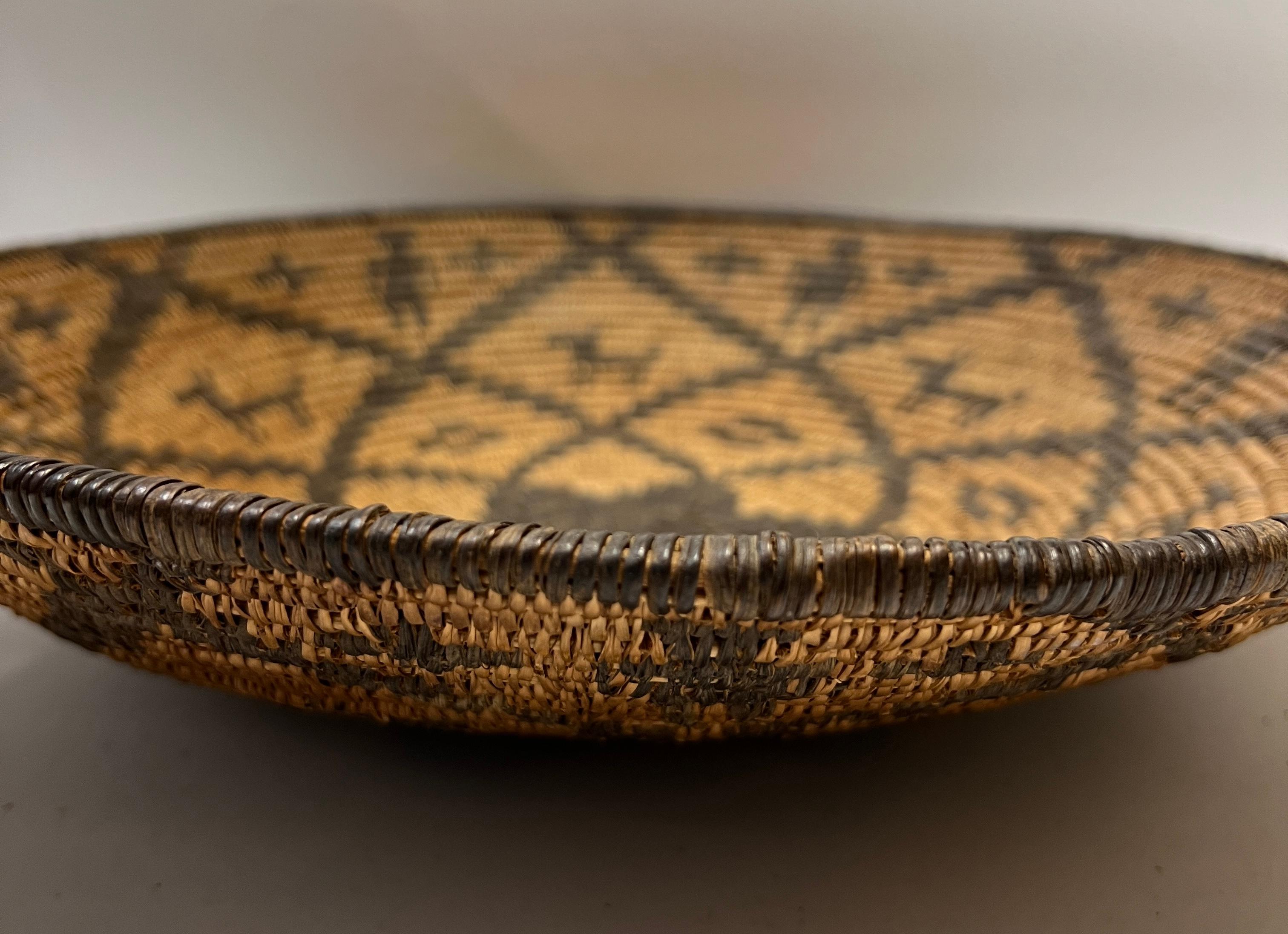 Woven Apache Basket with Dog and Human Motif
Late 19th century - Early 20th century
Woven from Willow and Devil's Claw

Apache is a collective term for several culturally related groups of Native Americans living primarily in the Southwest, which