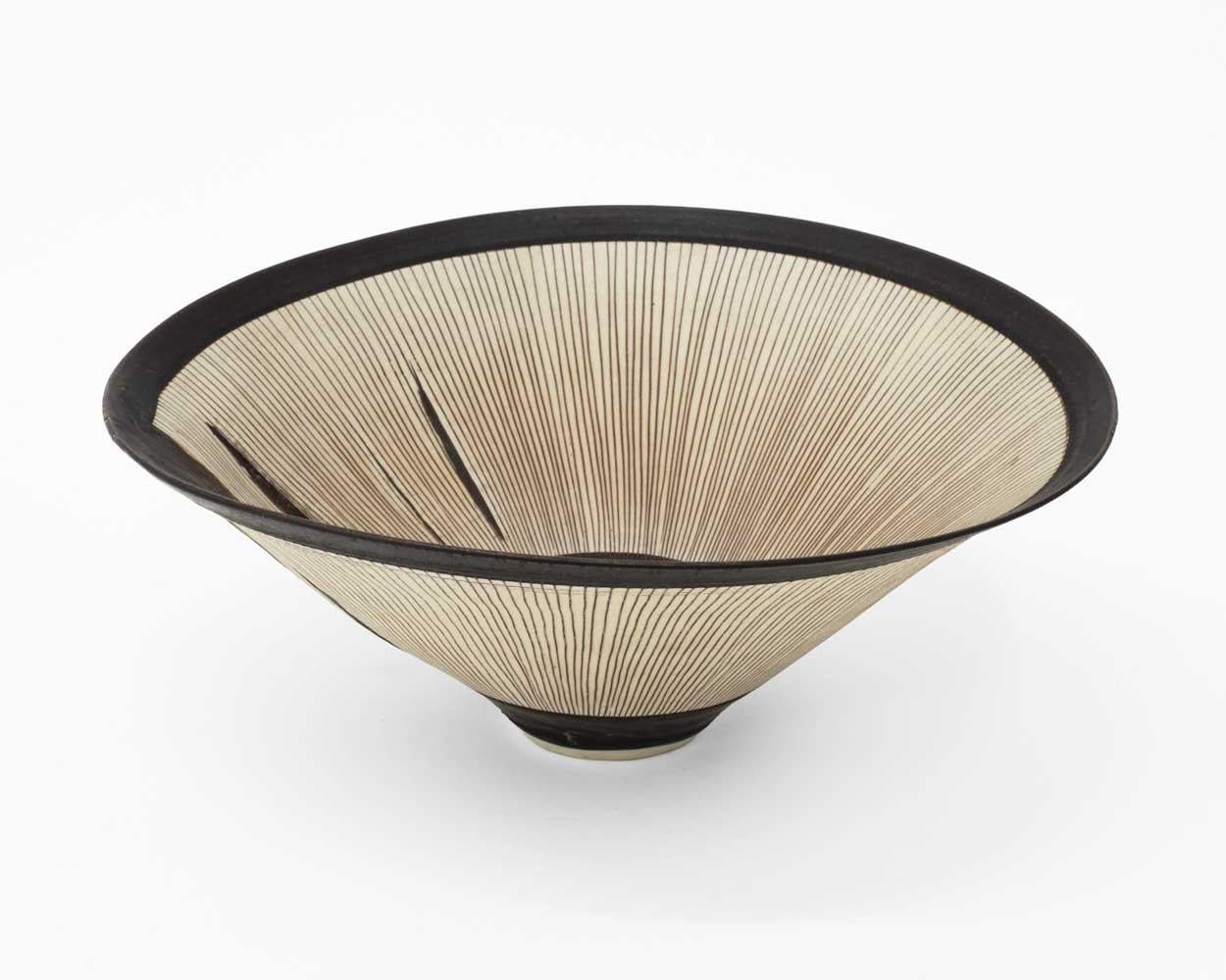 Impressed with artist’s seal 
Porcelain, radiating inlaid lines, manganese bands to rim and foot, with kiln splits 
5 x 11 1/2 inches
