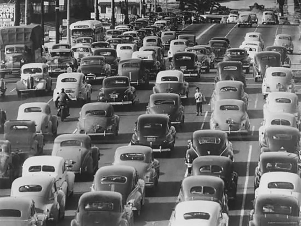 Loomis Dean Black and White Photograph - Boy Selling Newspapers, Los Angeles, Looking South on Olive Street, 1949