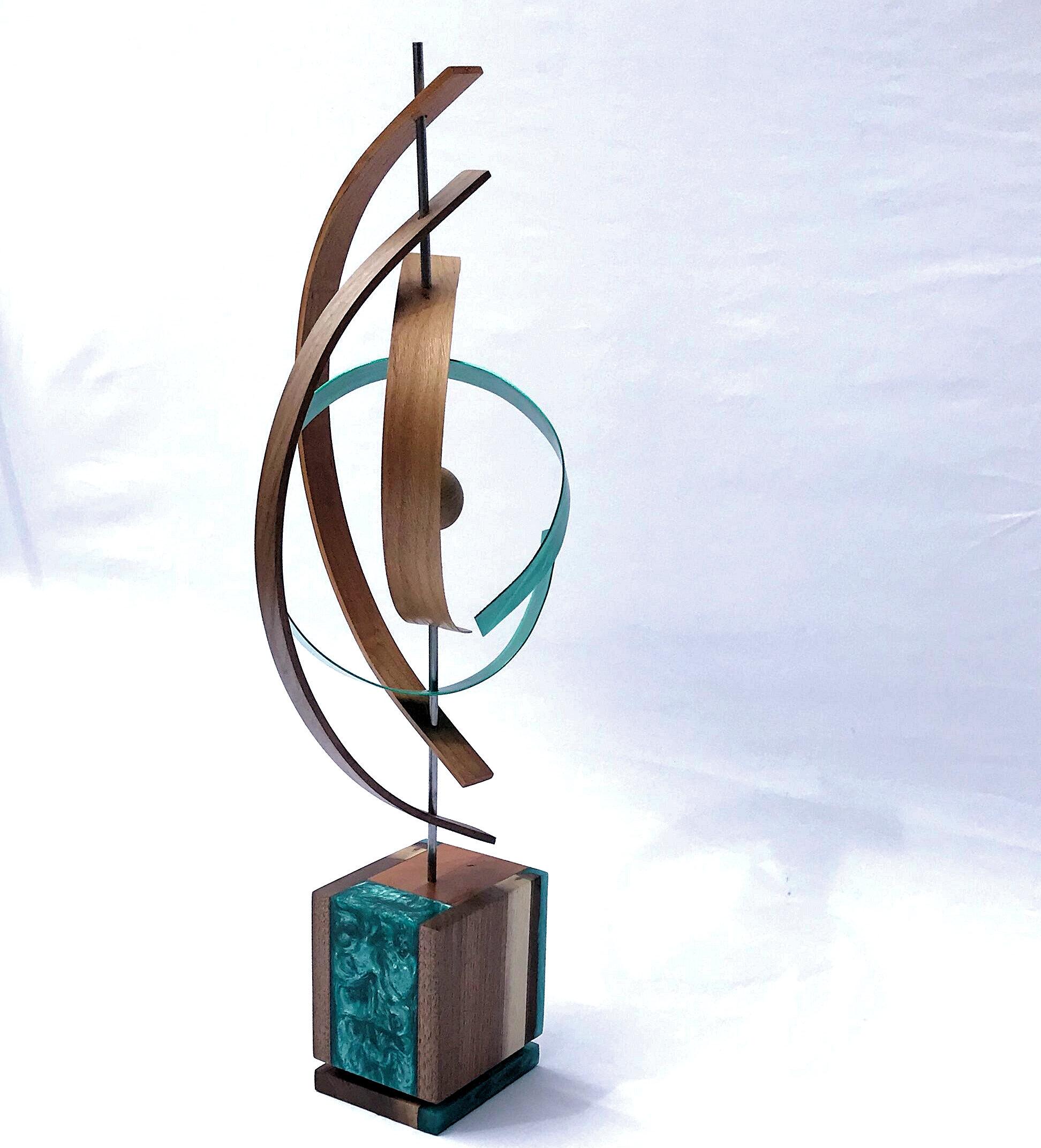 Title: Twister
Description: Formed black walnut and cherry slats twisting with blue/green aluminum slat while suspending a wooden sphere. The complementary base has a semi-gloss finish and features blue/green epoxy inlay with personalized turntable