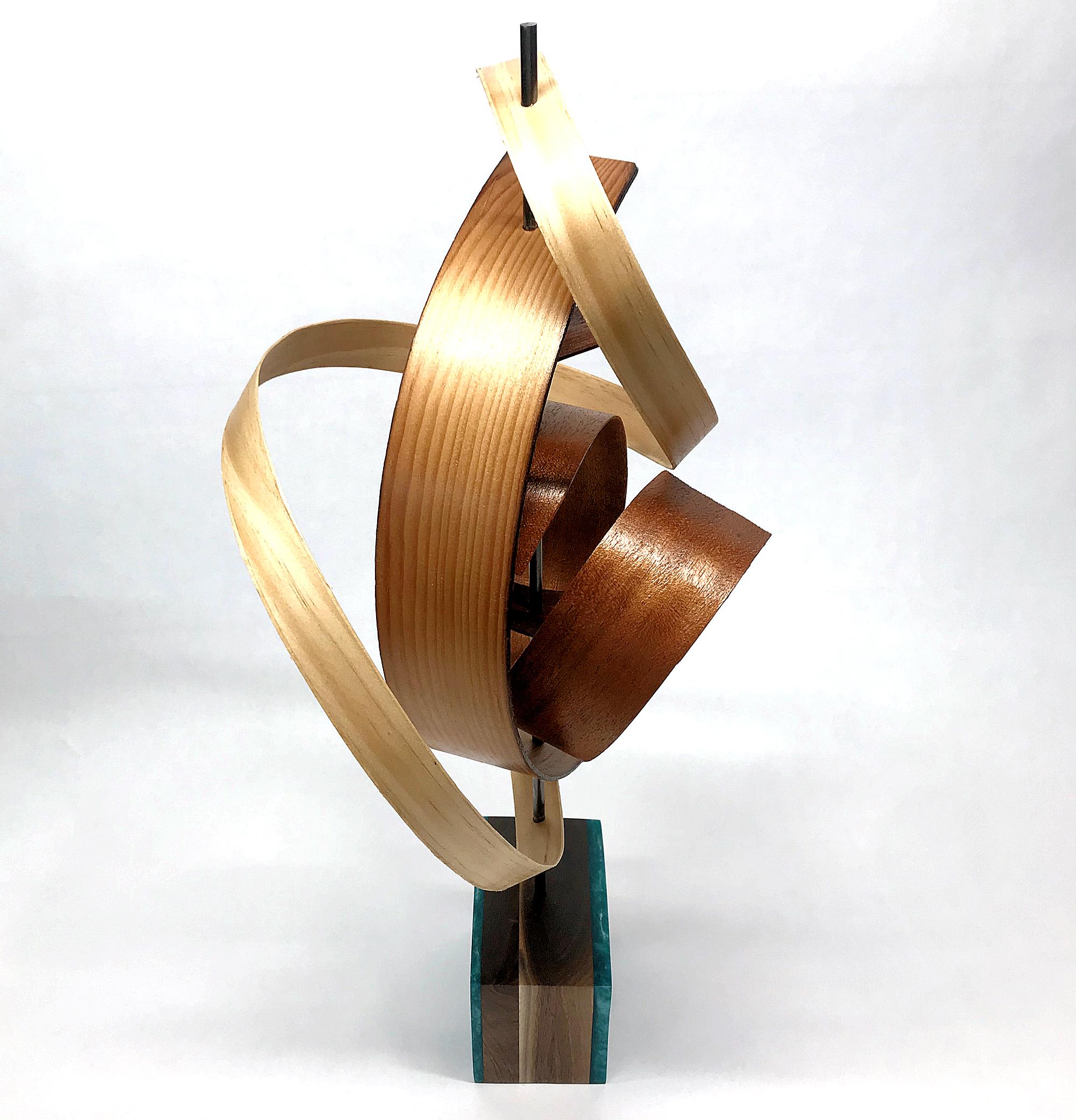 This Mid-Century Modern Inspired Wood Sculpture is comprised of pine and mahogany slats woven about a steel rod and sits atop a black walnut base which features green/blue epoxy accents. 
Title: Ribbon
Artist: Jeff Linenkugel

About the Artist:
Jeff