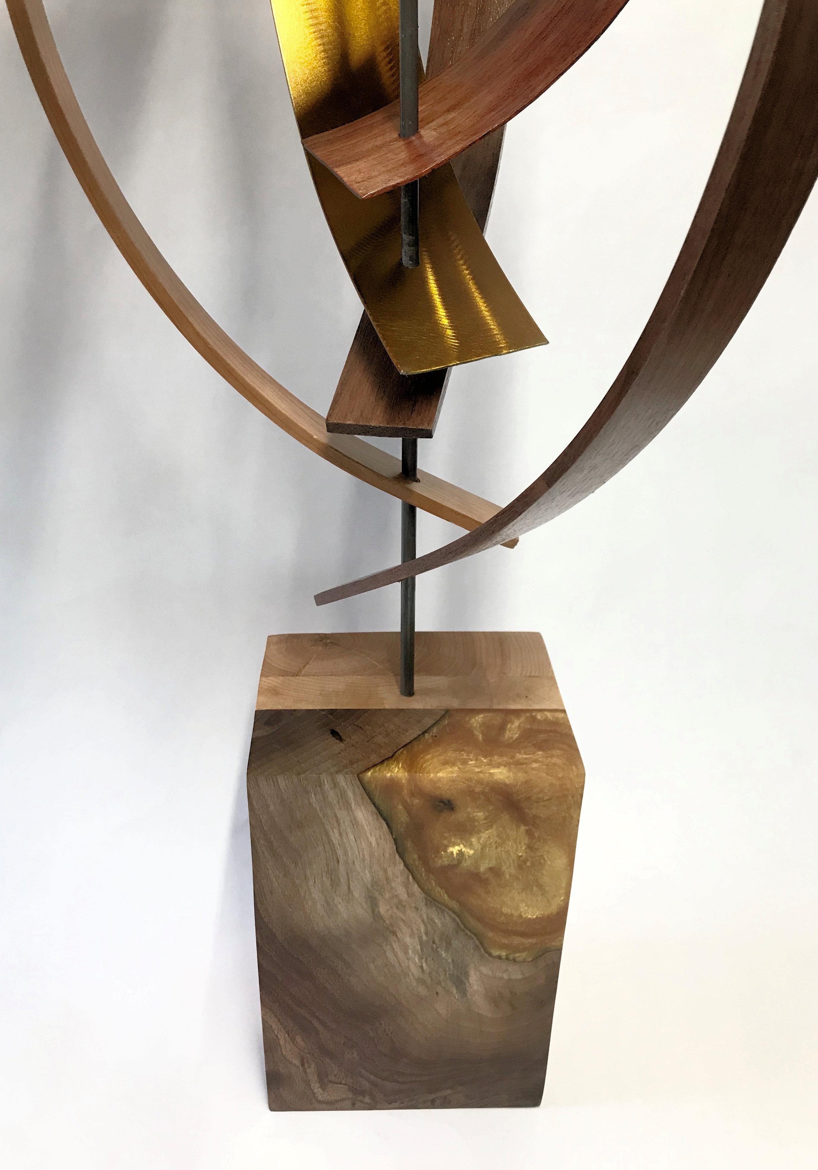 Description:  Black walnut, mahogany, and cherry wood slats are formed and woven together with aluminum slat, grind pattern and gold tint highlights.  The sculpture top is complimented by a walnut and cherry wood base with gold epoxy inlay accent,