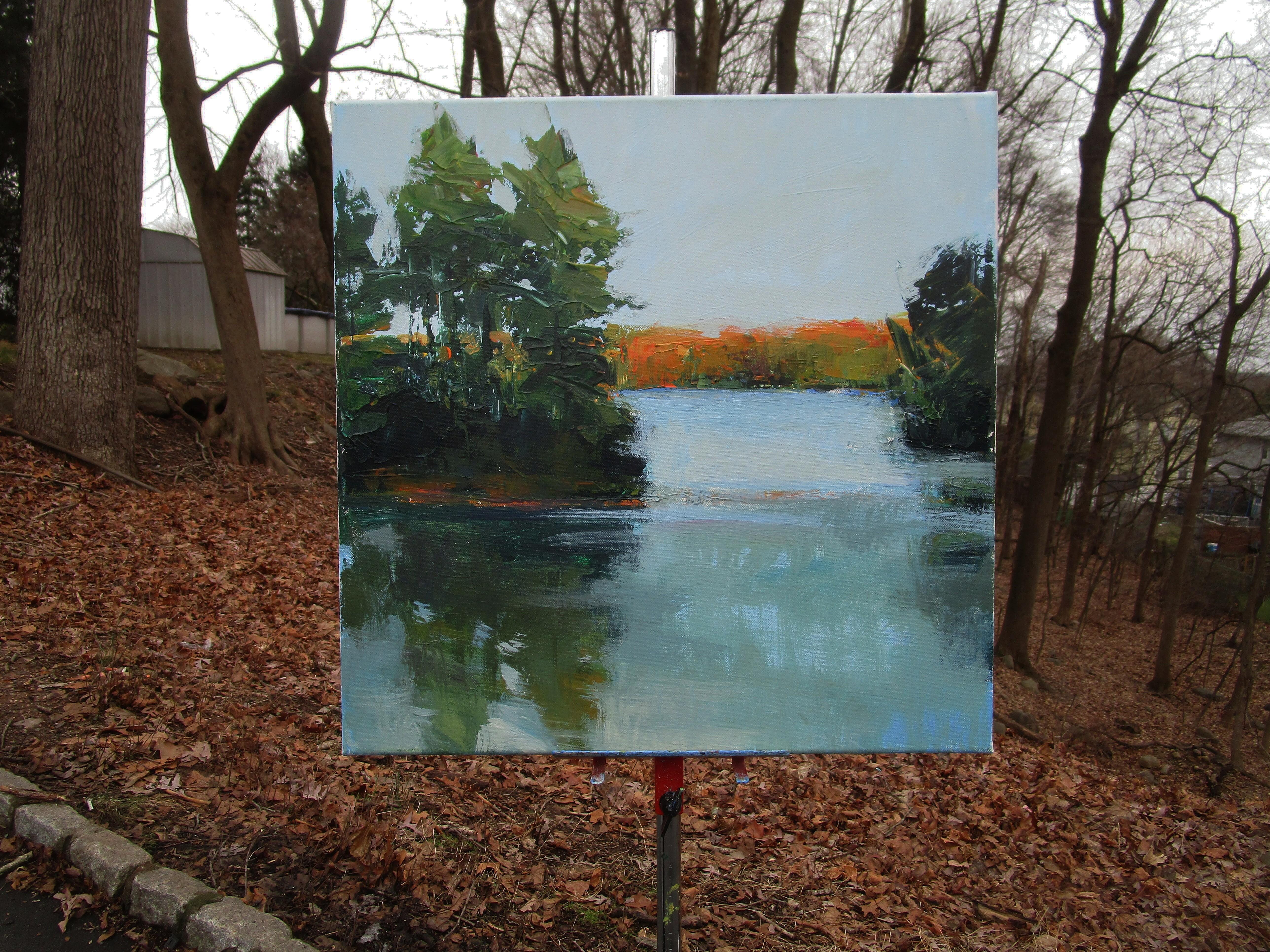 <p>Artist Comments<br>Artist Janet Dyer depicts a lake at sunset in a state park near her home. The tranquil water mirrors its surroundings, while the distant tree line remains bathed in the last rays of sunlight, intensifying the autumn hues of the