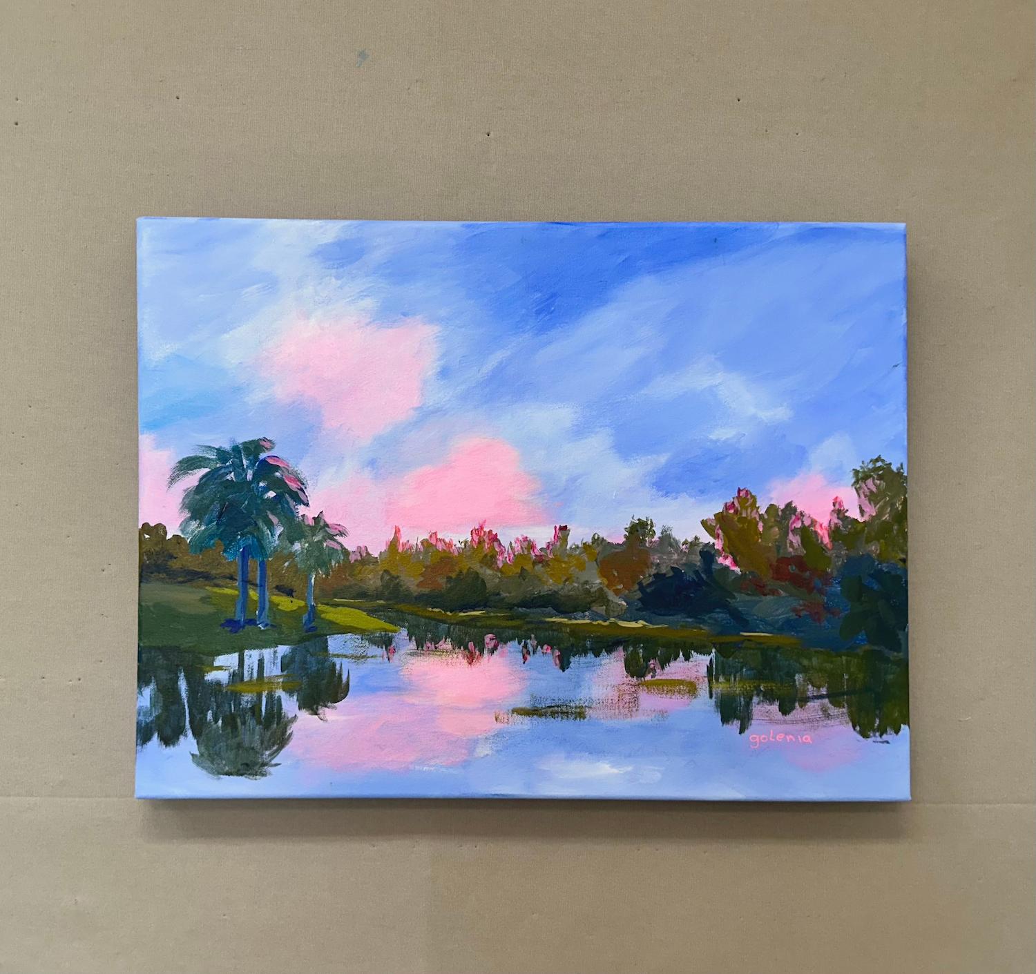 <p>Artist Comments<br>The rising sun hides behind the trees, casting their crowns in a soft red glow. Cotton candy clouds drift across the sky, their reflections dancing on the tranquil lake. This ethereal view will only last for a while, as every