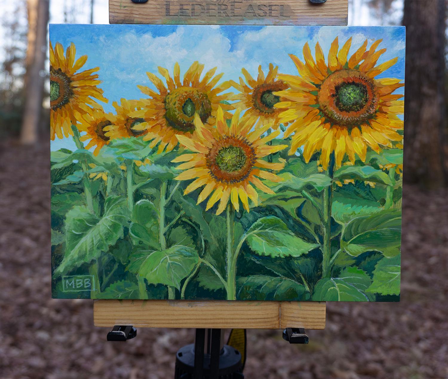 <p>Comentarios del artista<br>Los girasoles florecen en abundancia bajo un cielo azul de verano salpicado de nubes hinchadas. Unas exuberantes hojas verdes enmarcan los pétalos dorados, realzando su vivacidad. La escena irradia la alegre calidez del