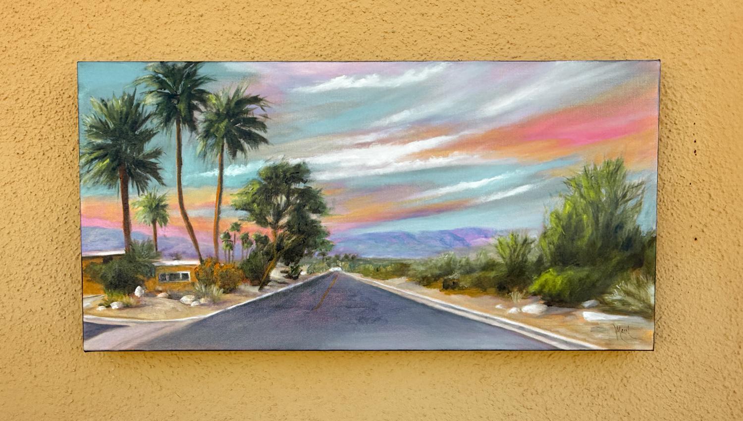 <p>Artist Comments<br>Palm trees and desert vegetation frame a road stretching into the distance. At the horizon, purple mountains rise under a sky filled with multicolored clouds. Artist Mandy Main's mid-century modern house appears on the left.