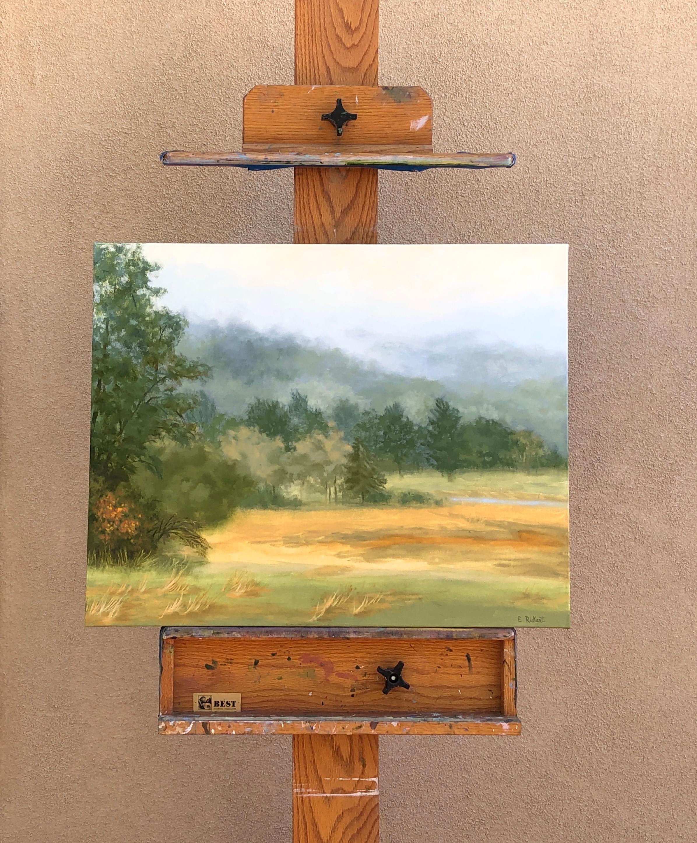 <p>Artist Comments<br />Elizabeth experienced this view while visiting an artist colony. She watched gentle fog roll over the treetops, creating a soft grey blanket over the rich green and golden landscape.</p><br /><p>About the Artist<br /></p><br