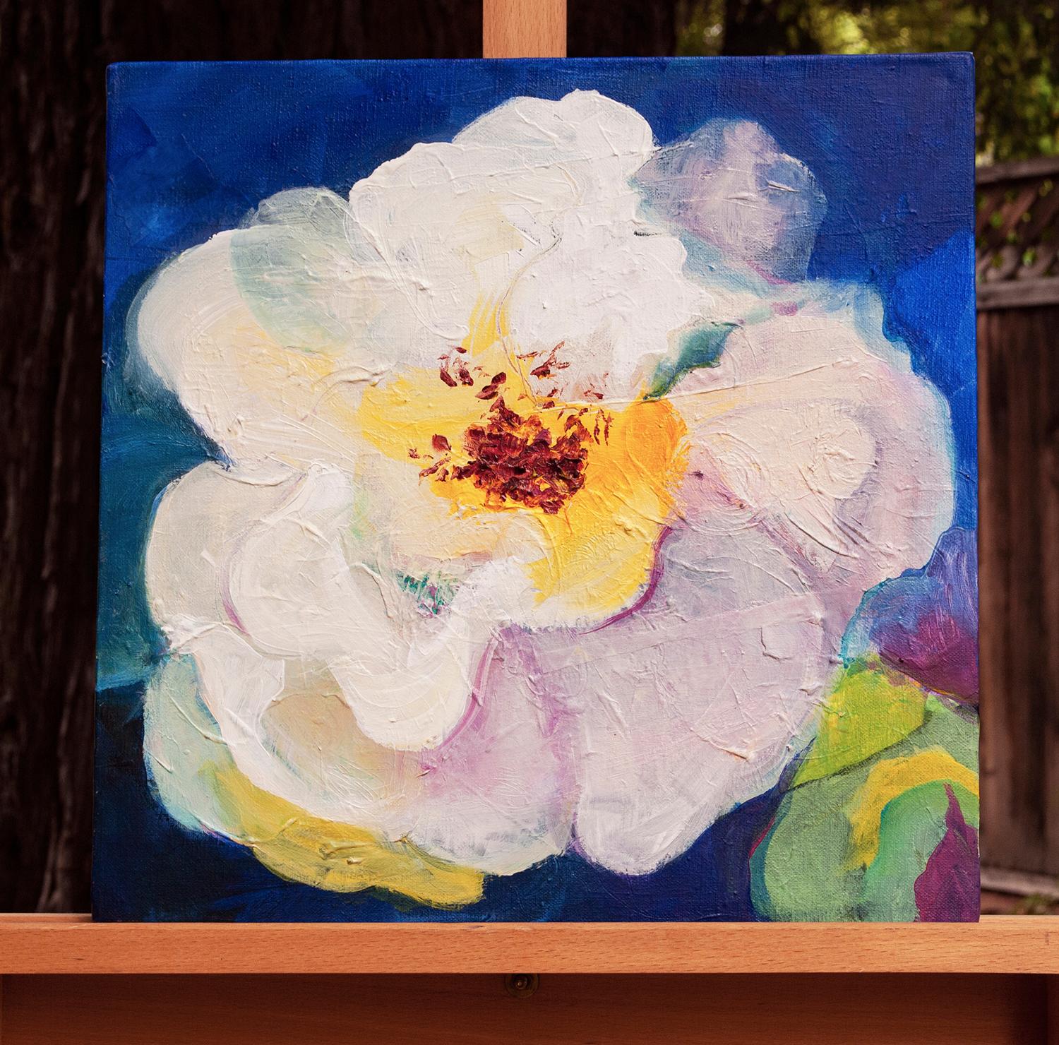 <p>Artist Comments<br />Flowing white blossom with nuanced layers of pink, violet, teal and yellow. A complementary blue backdrop gives the flower an alluring roundness. Ruth-Anne says the piece may seem simple at first glance but there are unique