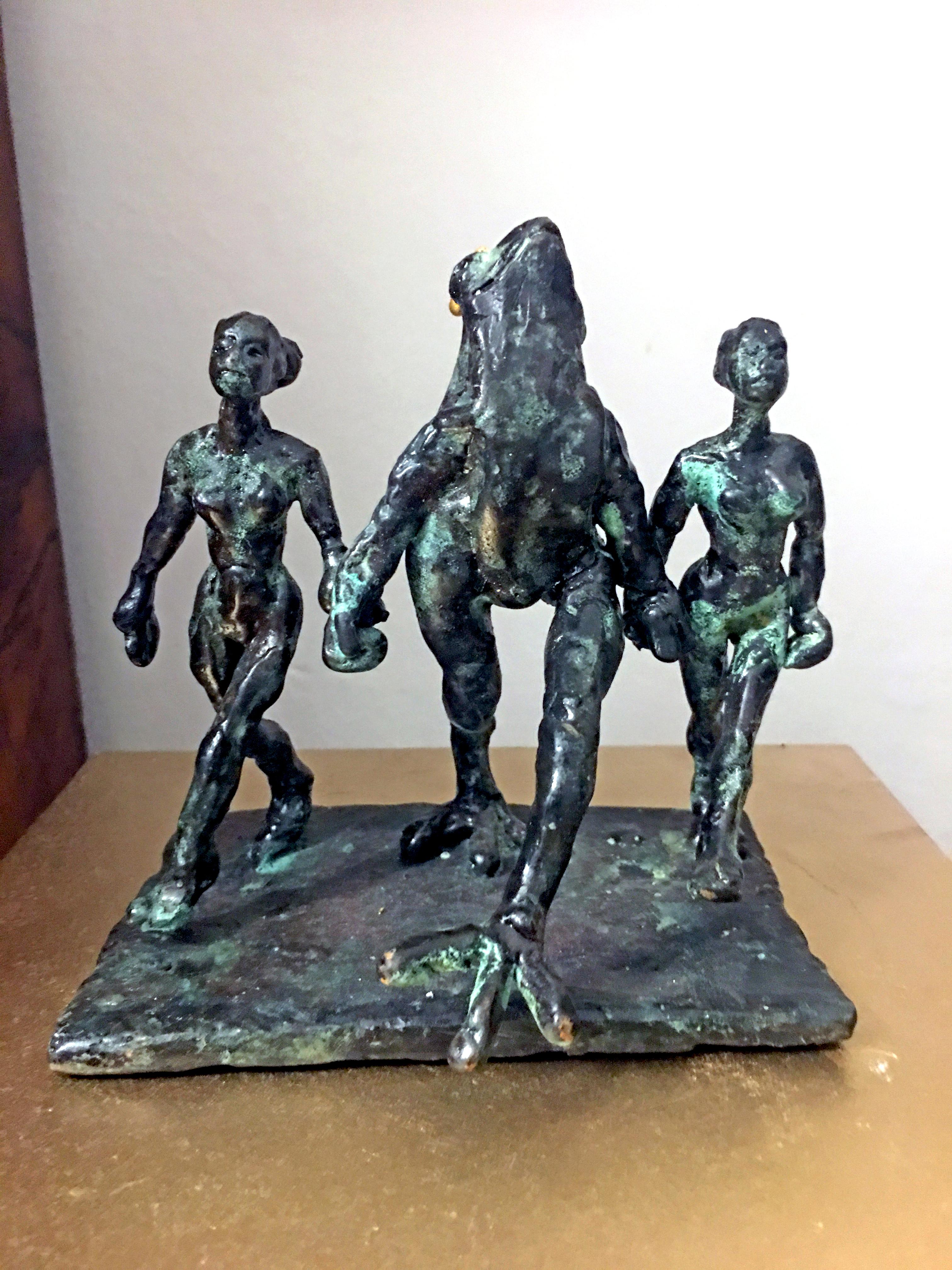 Bronze sculpture by Danish Artist Helle Crawford of a frog accompanied by two women dancing.
