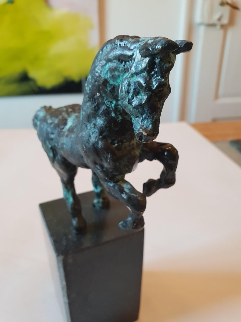 Bronze sculpture of a horse that rears on granite base