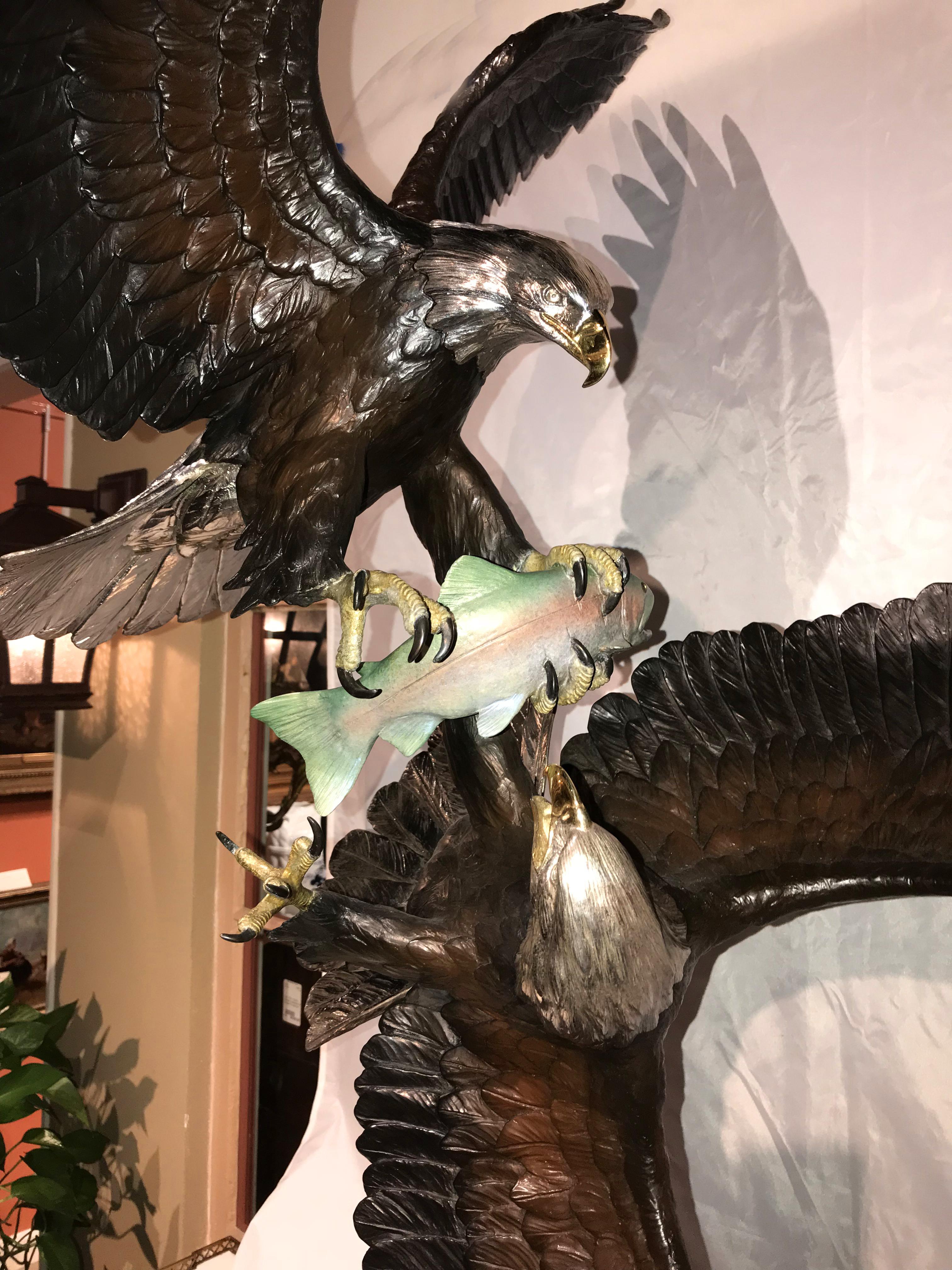 This exceptional limited edition cast and painted bronze of two bald eagles fighting for a trout was done by American sculptor Mike Curtis (20th/21 century). Mike Curtis, a resident of Idaho with a studio near Lake Pend Oreille, is well known for