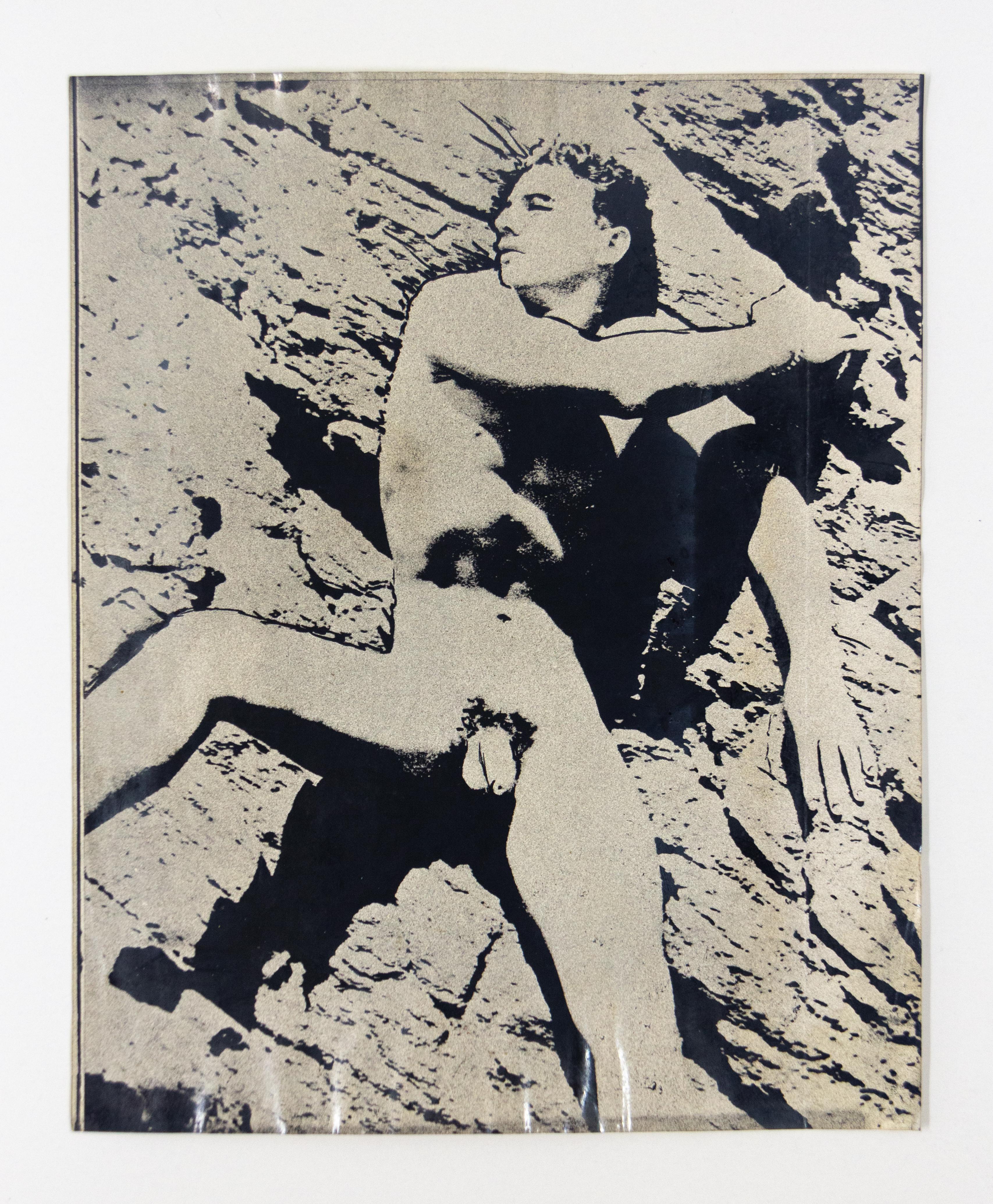 Nudefarbenes männliches Model posiert vor Rock Face – Photograph von John S. Barrington