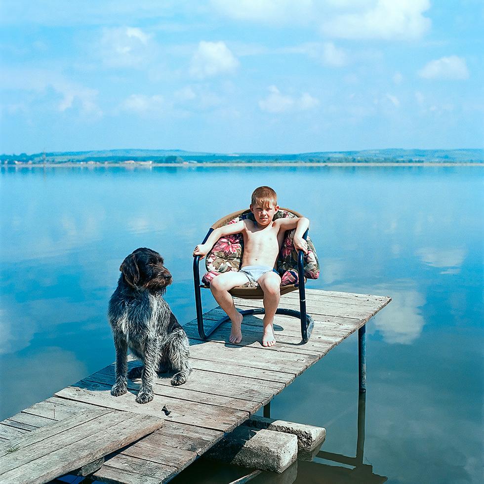 Evžen Sobek Color Photograph – Ohne Titel (Junge mit Hund)