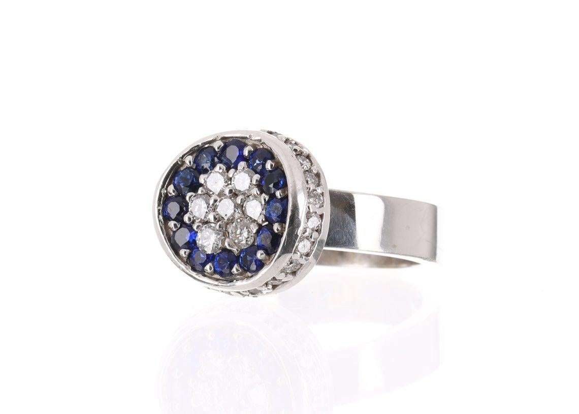 Showcased is a superb sapphire and diamond ring that is full of life and exuberance from any view. Twelve fully faceted sapphires are prong set in a halo and are beautifully accented by an inner cluster of brilliant diamonds. The natural sapphires