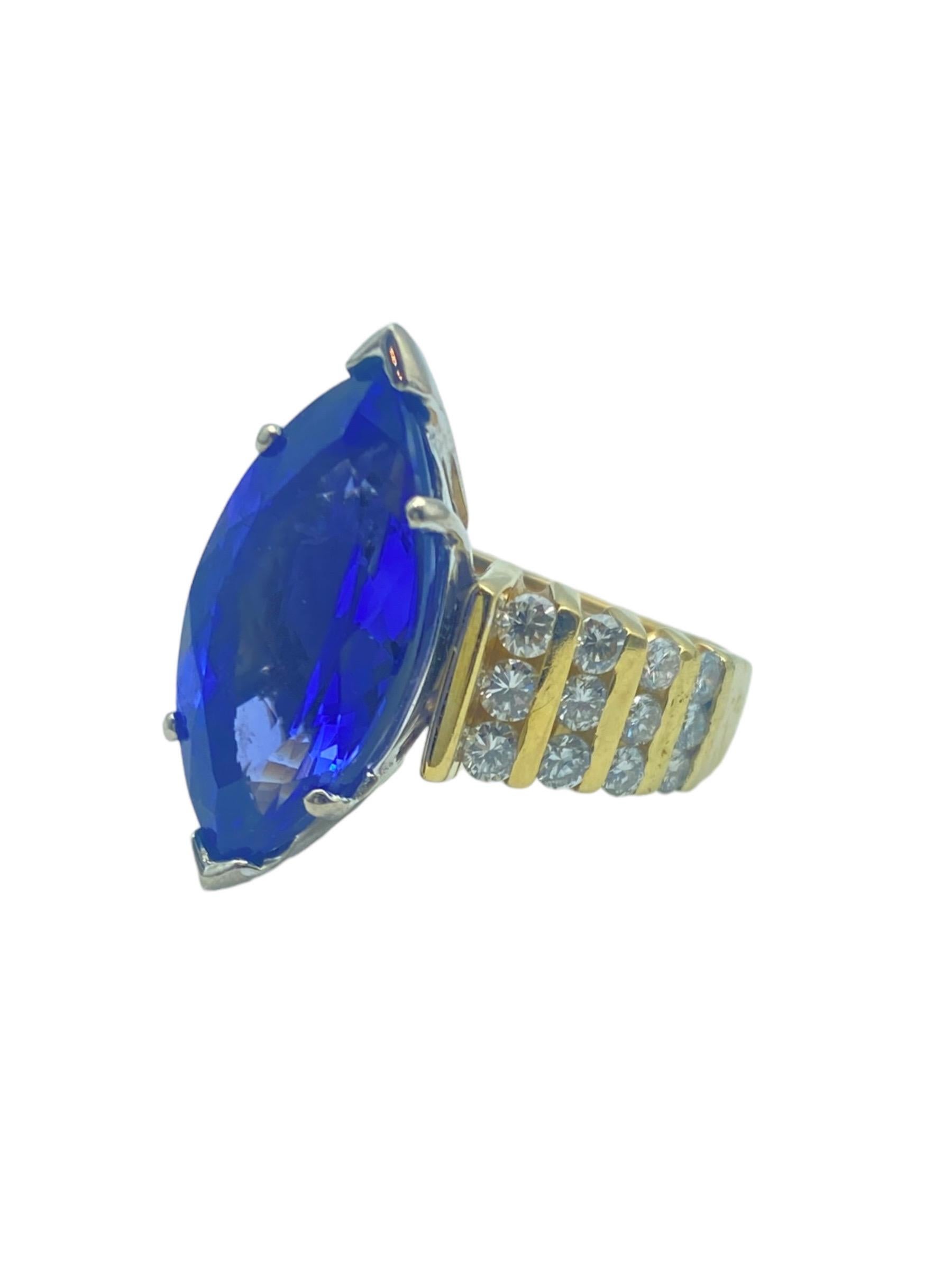 Cette tanzanite de qualité AAA est une pierre précieuse de couleur profonde et de haute qualité, taillée en forme de marquise. La bague est rehaussée de vingt-quatre diamants ronds et de taille brillant de part et d'autre de l'anneau (au total). Les