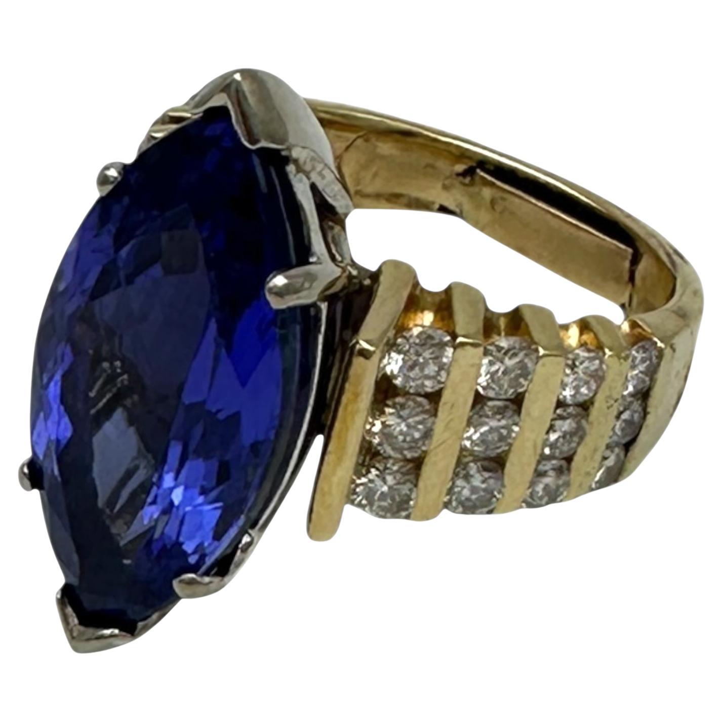Dieser AAA-ausgezeichnete Tansanit ist ein tief gefärbter, hochwertiger Edelstein im Marquise-Schliff. Der Ring ist mit vierundzwanzig Diamanten im Rund- und Brillantschliff auf beiden Seiten des Rings besetzt (insgesamt). Die Diamanten haben ein