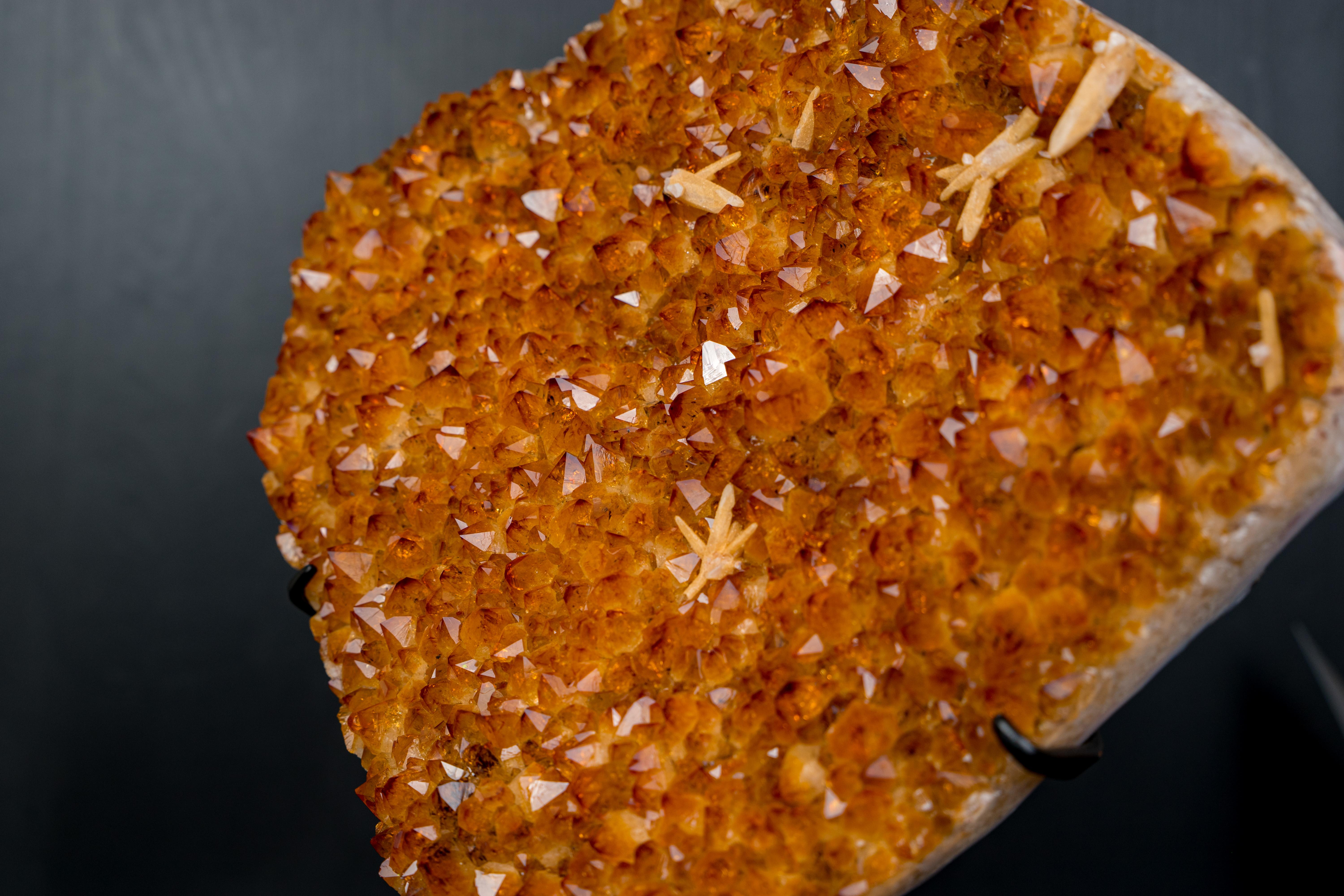 AAA Golden-Orange Citrine Cluster on Stand

�▫️ Description

With an aesthetical, strong visual presence and rare, high-grade characteristics, this large citrine cluster forms an array of sparkles, creating a high-energetic piece that brings elegance