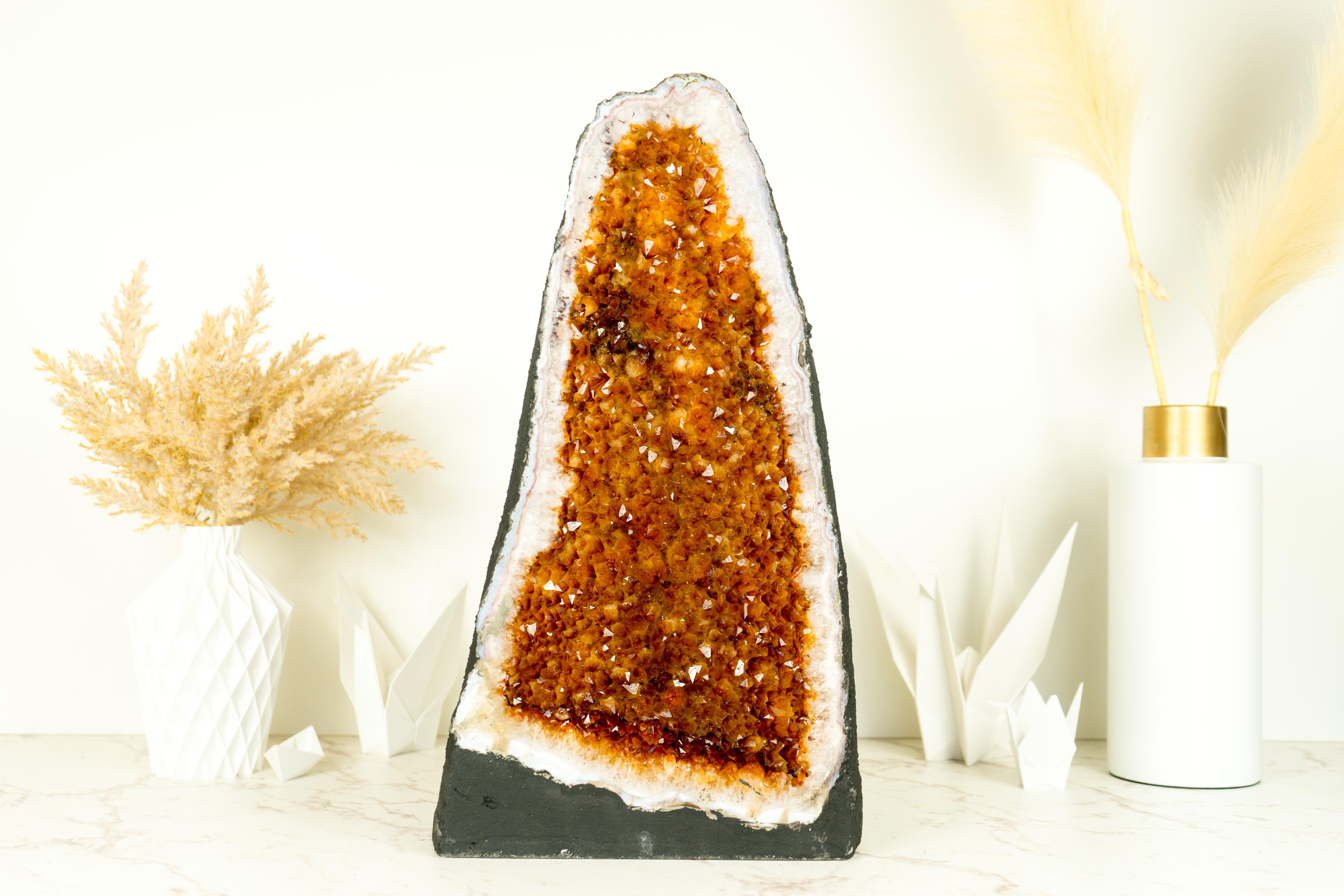 With its perfectly formed Geode Cathedral format and shimmering AAA-grade orange citrine druzy, this Citrine Geode will undoubtedly elevate the aesthetic of any environment, whether as a centerpiece in your collection or a captivating focal point in