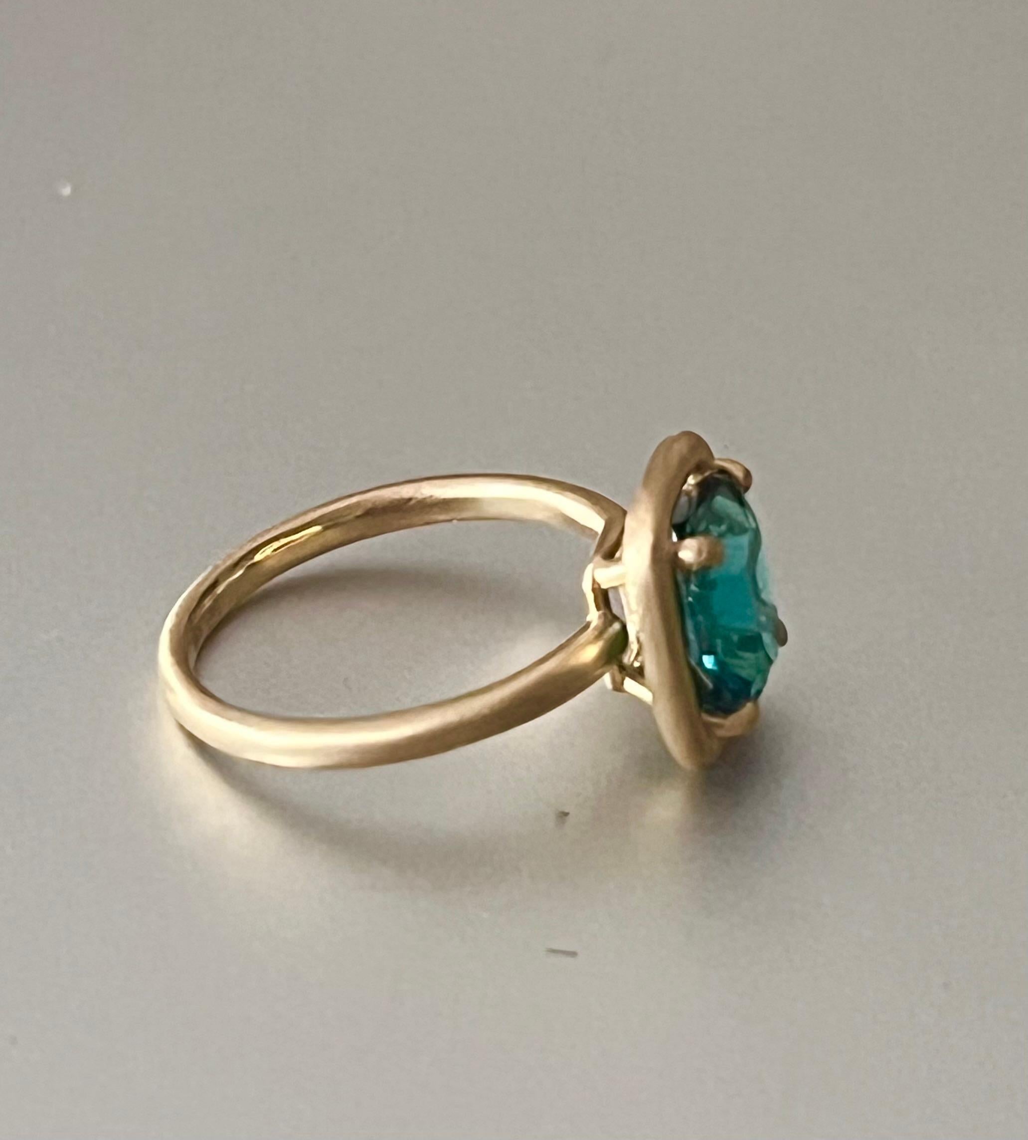 This is an unbelievable gem, AAA Indicolite, or Blue Tourmaline 2.5cts.  Set in solid 18K yellow gold with a satin finish.  Size is a 6 but easily sized by the designer, or any good jeweler.  

Please feel free to ask questions, Rachel has been