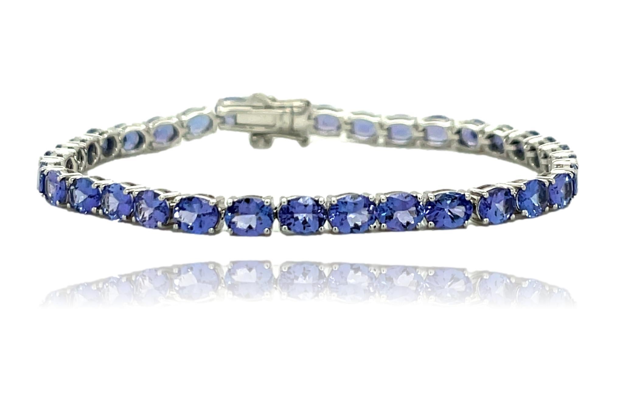 Ce magnifique bracelet de tennis en or blanc 18 carats comporte 34 Tanzanites ovales de qualité AAA, toutes serties sur 4 anneaux. Le bracelet mesure 7