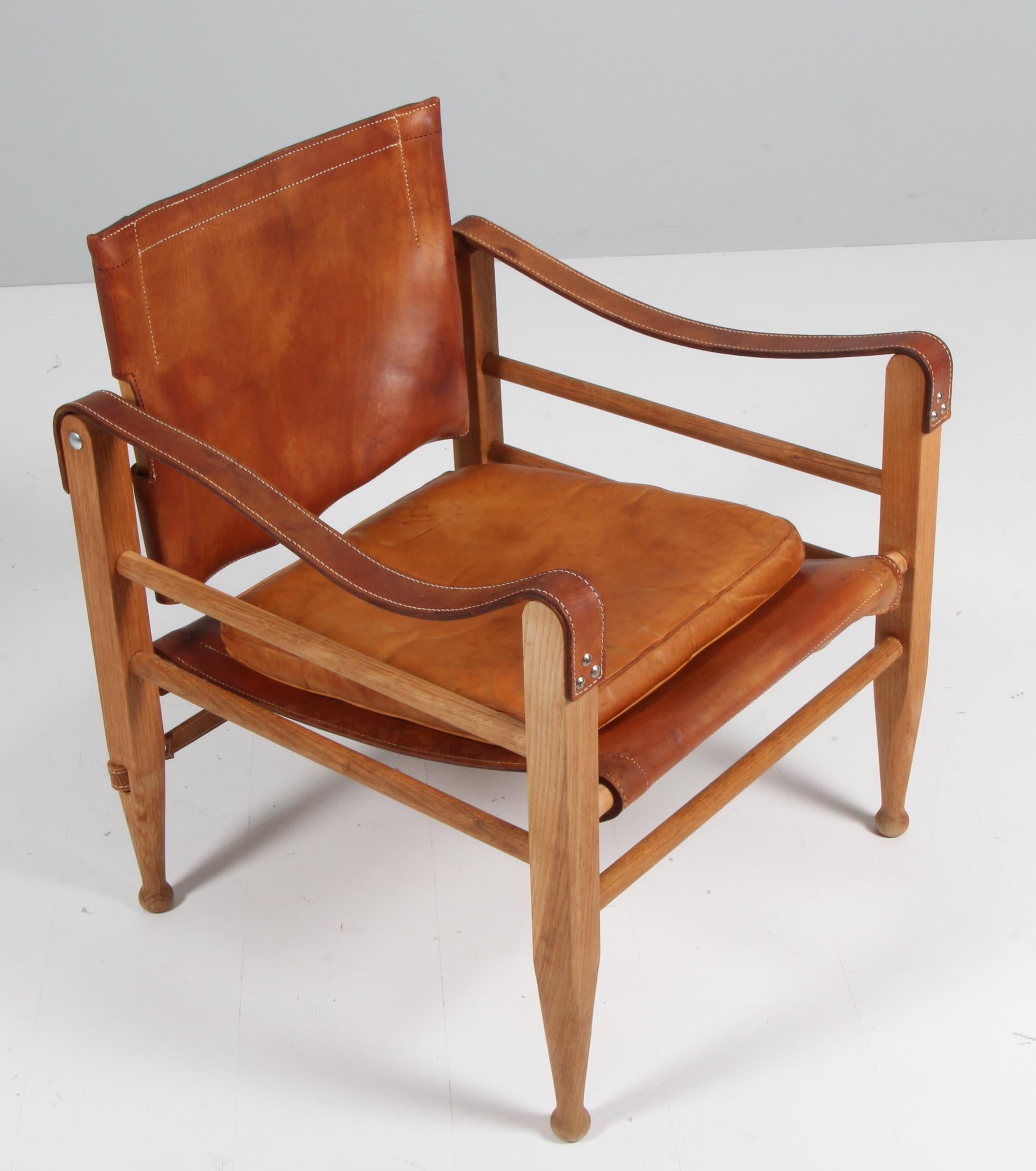 Aage Bruun & Son safari chair with frame of oak. Seat, back and armrests of patinated cognac saddle leather. 

Made in the 1960's by Aage Bruun & Son.