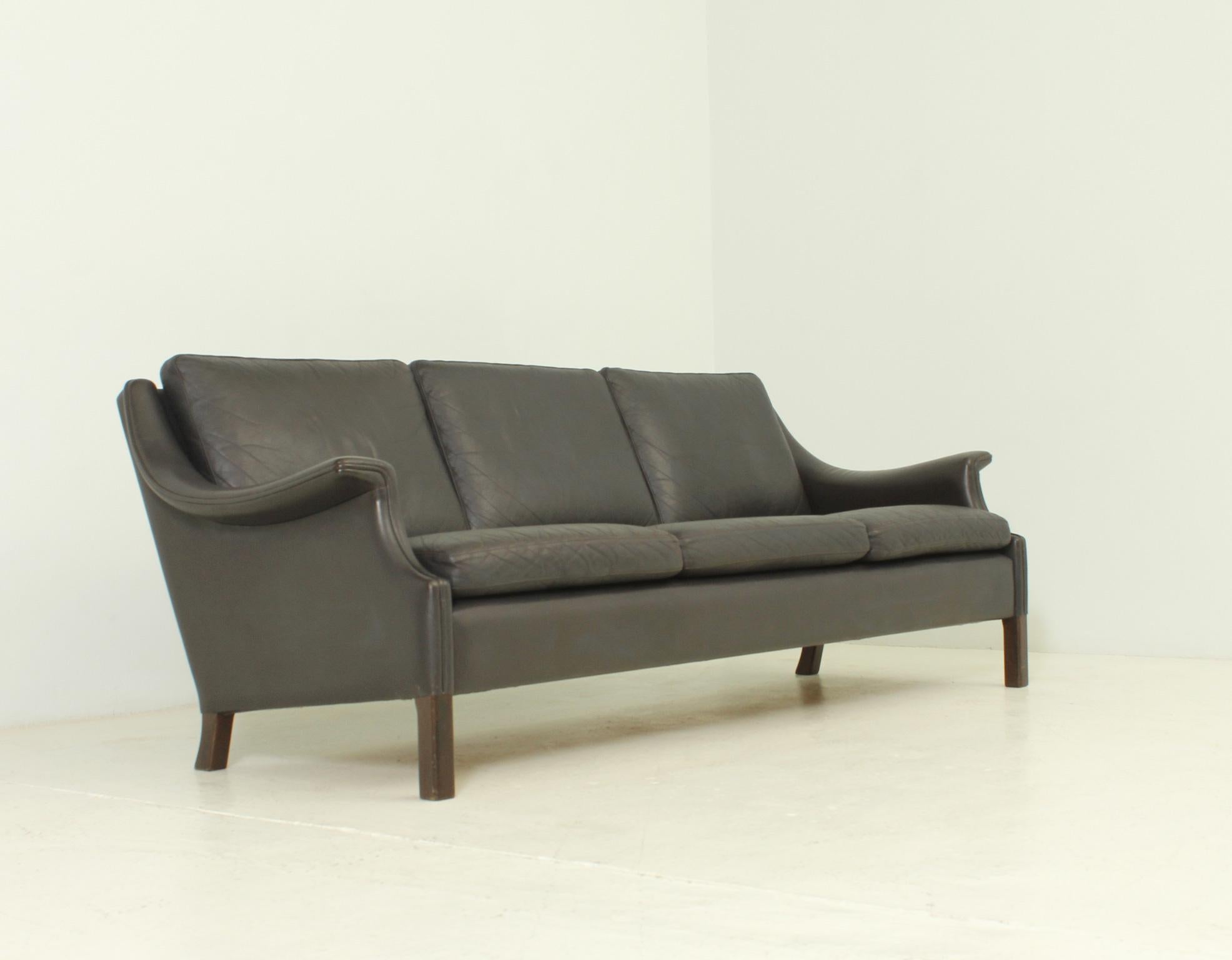 Three-seater danish sofa from 1960's designed by Aage Christiansen for Erhardsen & Andersen. Dark brown leather and wooden frame with loose cushions.