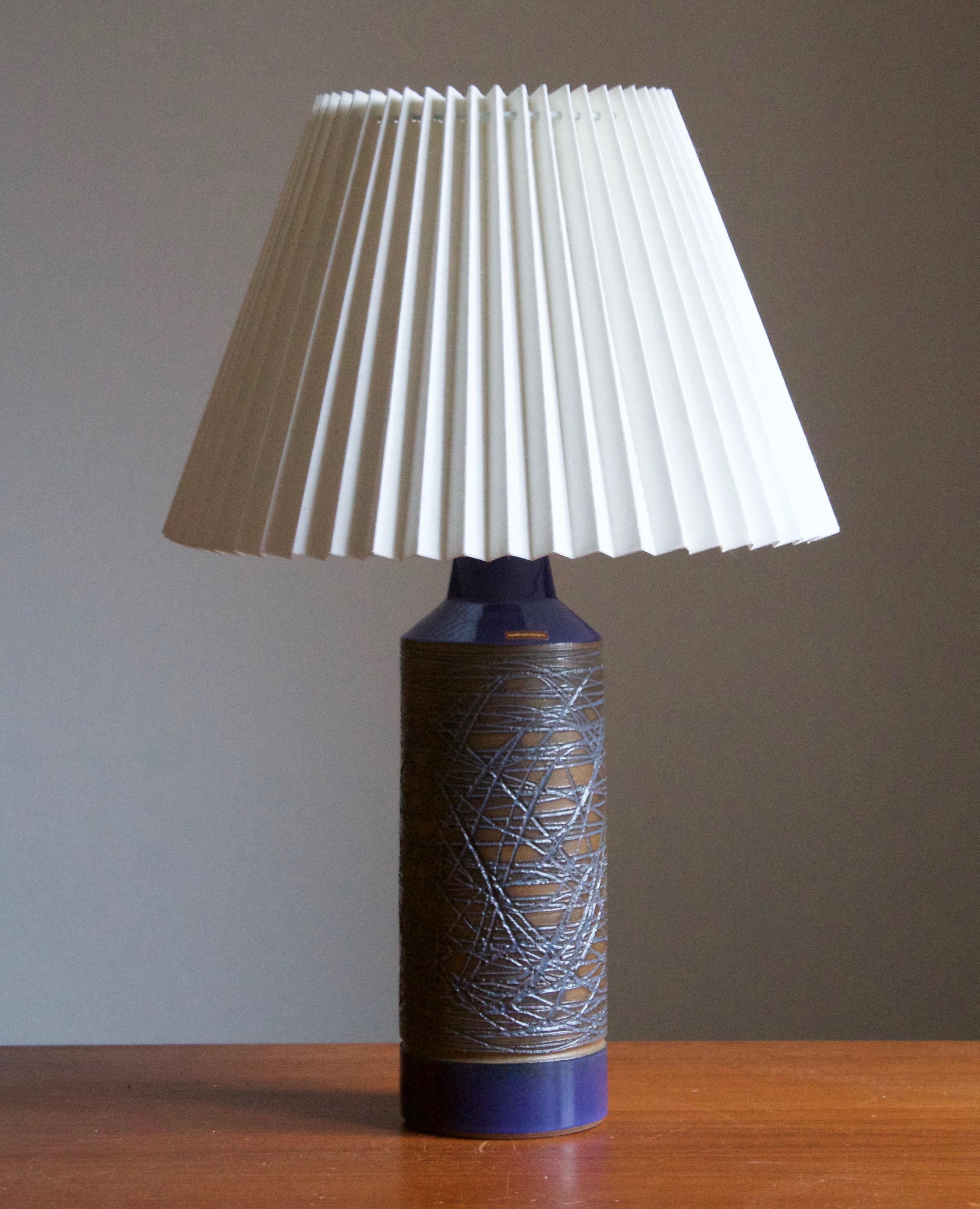 A table lamp produced by Danish ceramicist Aage Rasmus Selsbo in his studio, Simlångsdalen, Sweden, 1960s. Features Blue glaze and subtle incised decoration. Labeled.

Sold without lampshade. Stated dimensions exclude lampshade, height includes