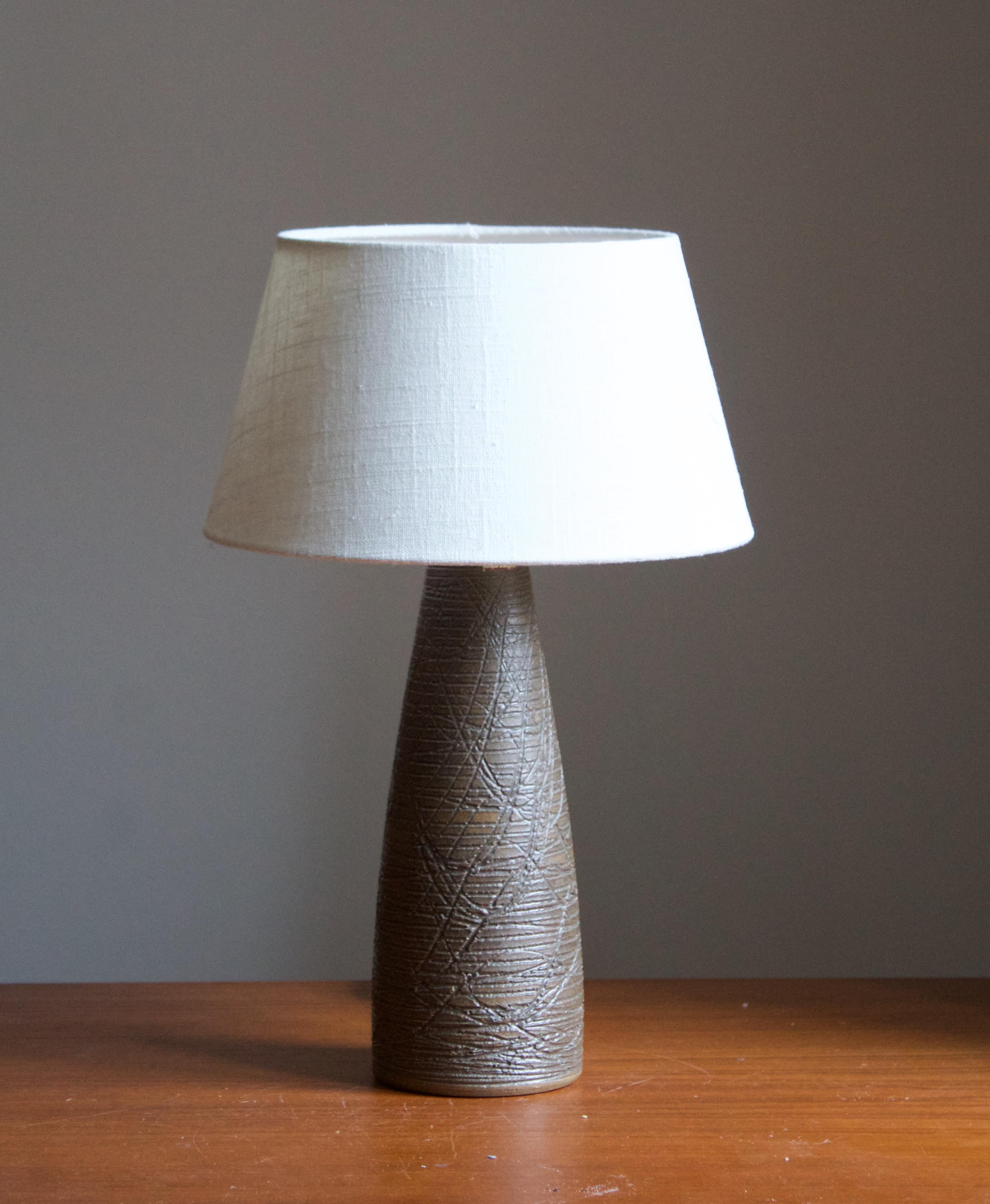 A table lamp produced by Danish ceramicist Aage Rasmus Selsbo in his studio, Simlångsdalen, Sweden, 1960s. Features Brown glaze and subtle incised decoration. Labeled and signed.

Sold without lampshade. Stated dimensions exclude lampshade, height