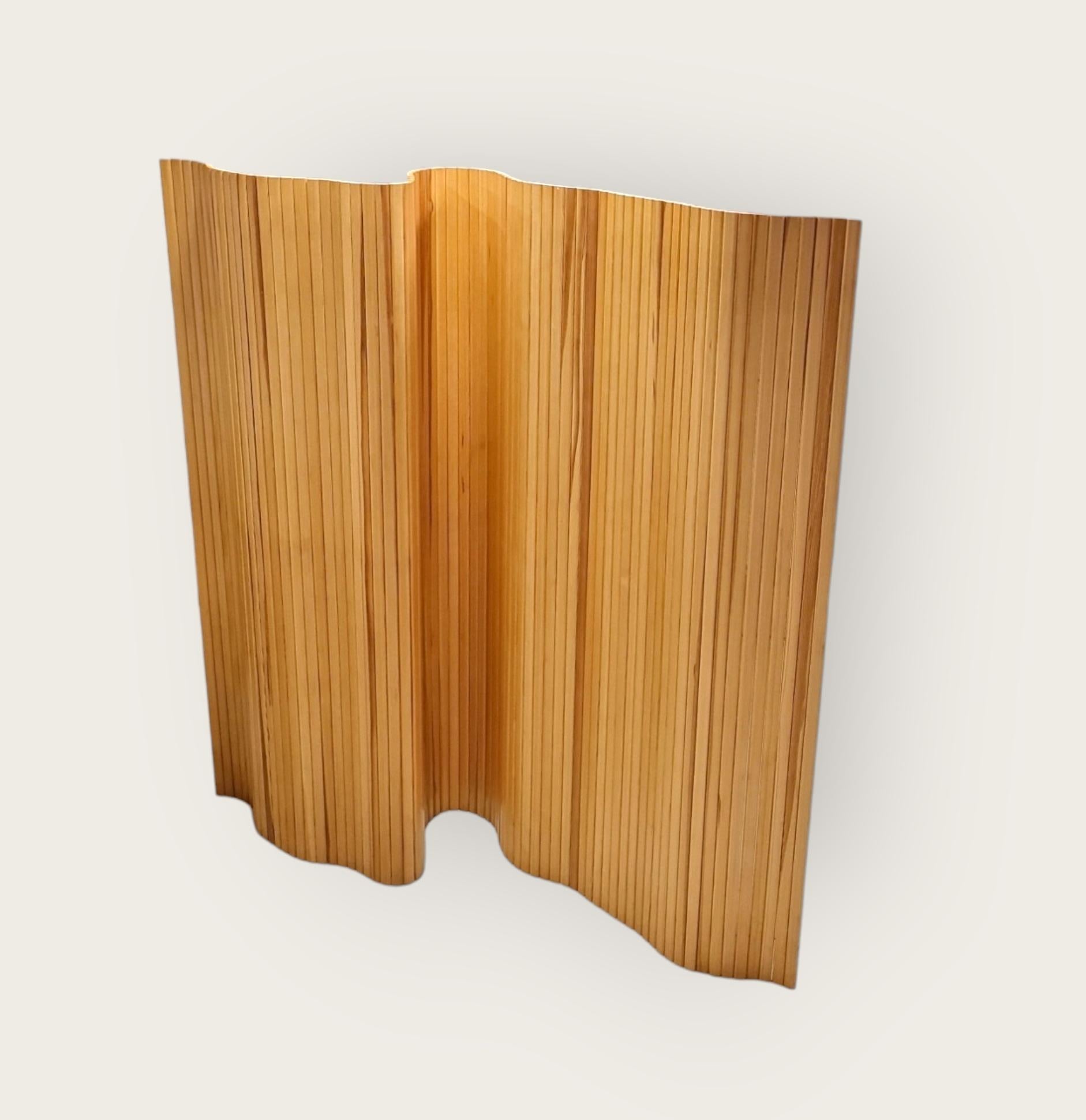 
The 100 slatted wall / room divider by Alvar Aalto is a dynamic interior element assembled from narrow vertical pine slats and can be rolled up and opened as a straight or in numerous curved positions. At 150-centimeter-high, the slatted wall