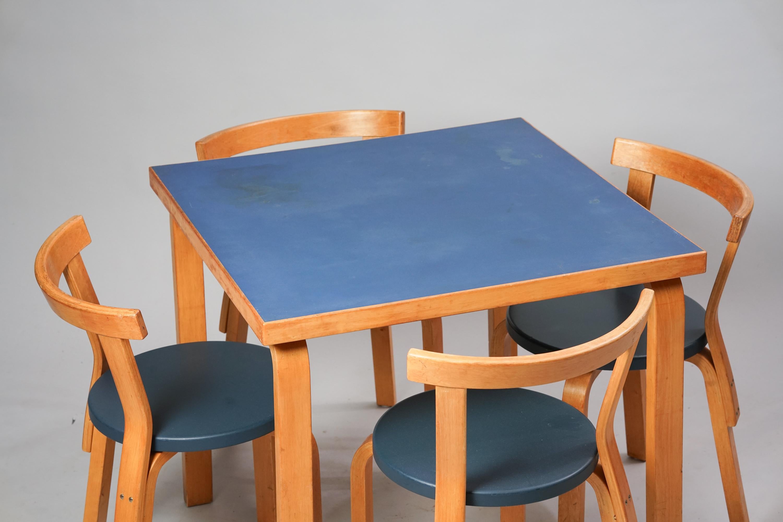 Tisch und vier Stühle Modell 68, entworfen von Alvar Aalto, hergestellt von Oy Huonekalu- ja Rakennustyötehdas Ab, 1950er Jahre. Tischplatte aus Linoleum, Birke, Polsterung der Stühle aus Kunstleder (Kerni). Der Tisch und die Stühle werden als Set