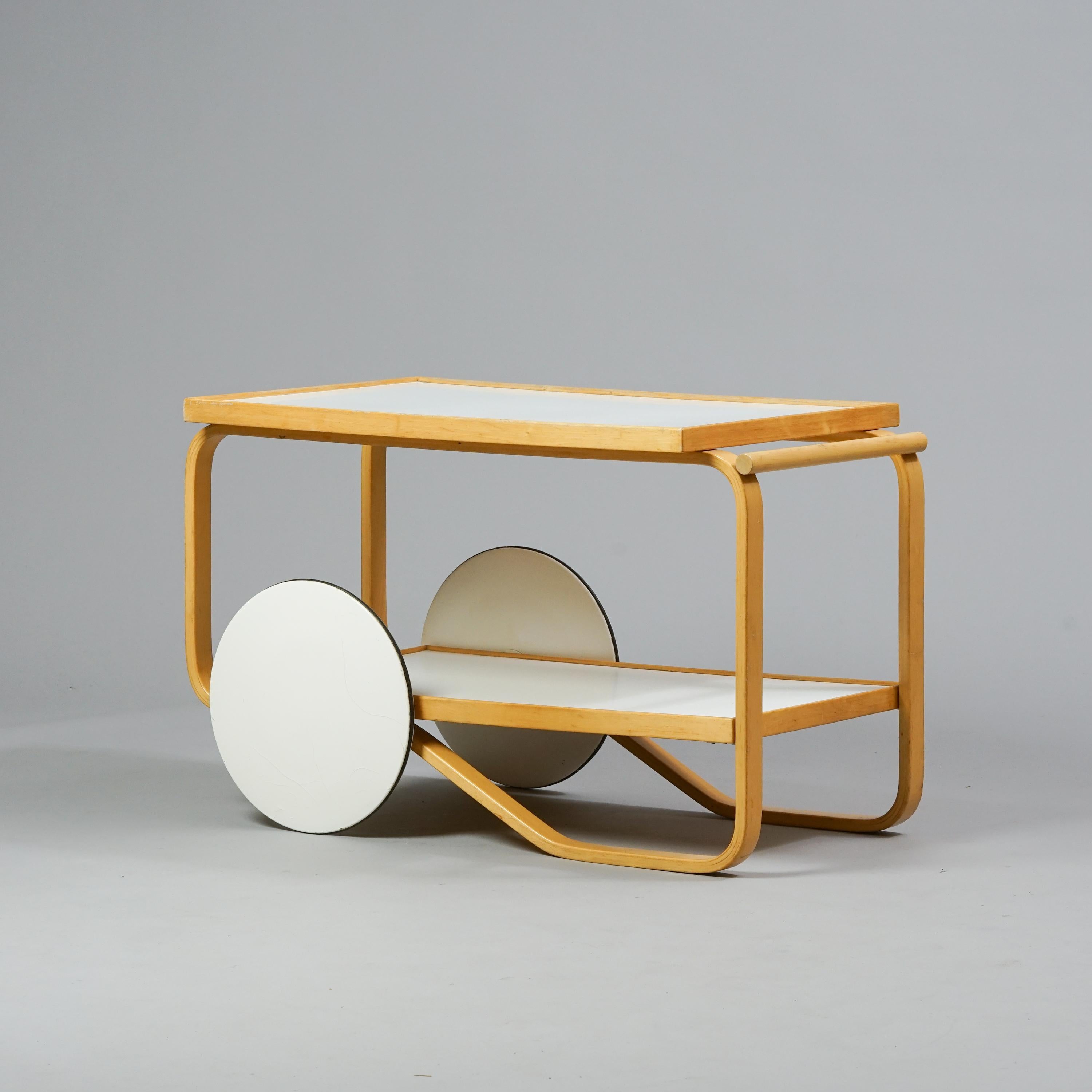 Aalto Tea Trolley Model 901 for Artek, circa 1950s. Model created in the 1930s. White linoleum top with birch frame and white lacquered wood wheels with rubber rings. Good original condition. 
 