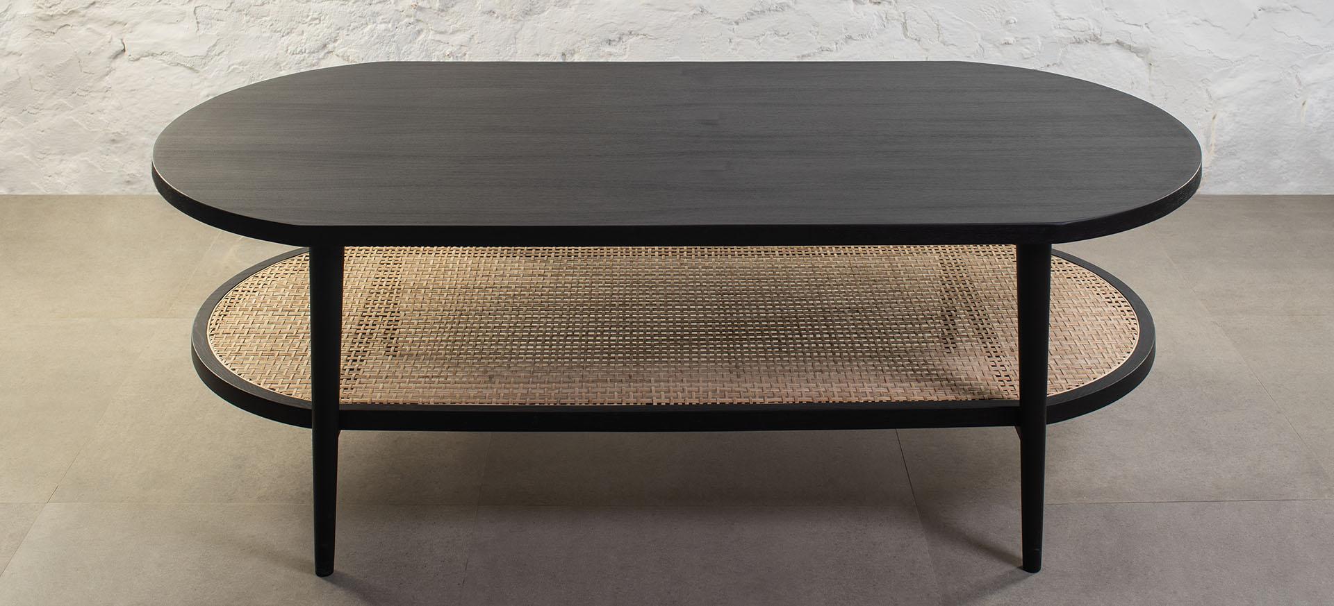 Utilisant une forme de pilule polyvalente, cette table basse a été conçue pour créer une déclaration douce grâce à l'utilisation de sa géométrie subtile et de son plateau en rotin à motifs, tout en restant pratique et légère pour s'adapter à