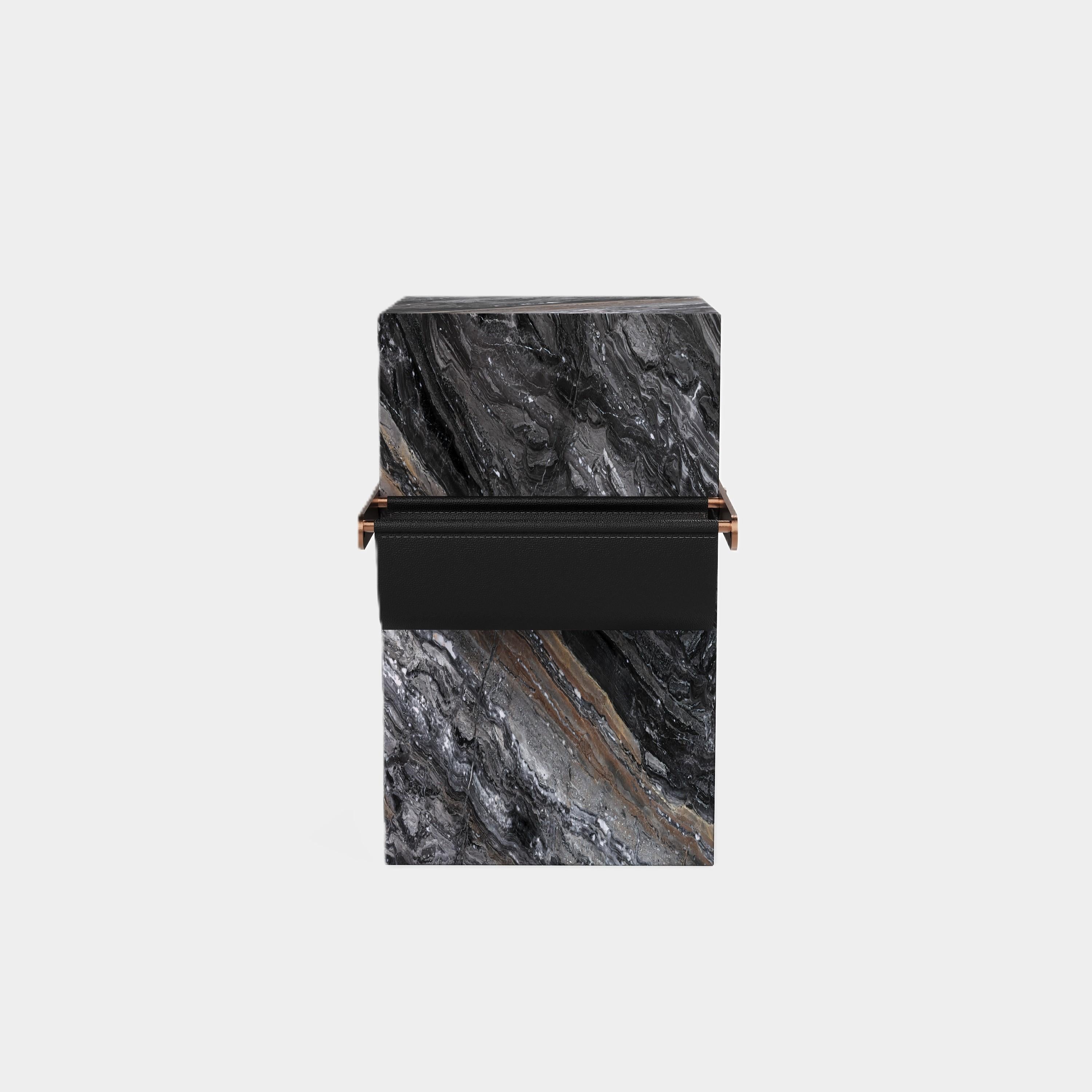 A contemporary side table, crafted from solid marble with intricate natural patterns. Its sculptural design offers dual purpose as a side table as well as providing a unique way to organise and display your favourite magazines or books.

The black