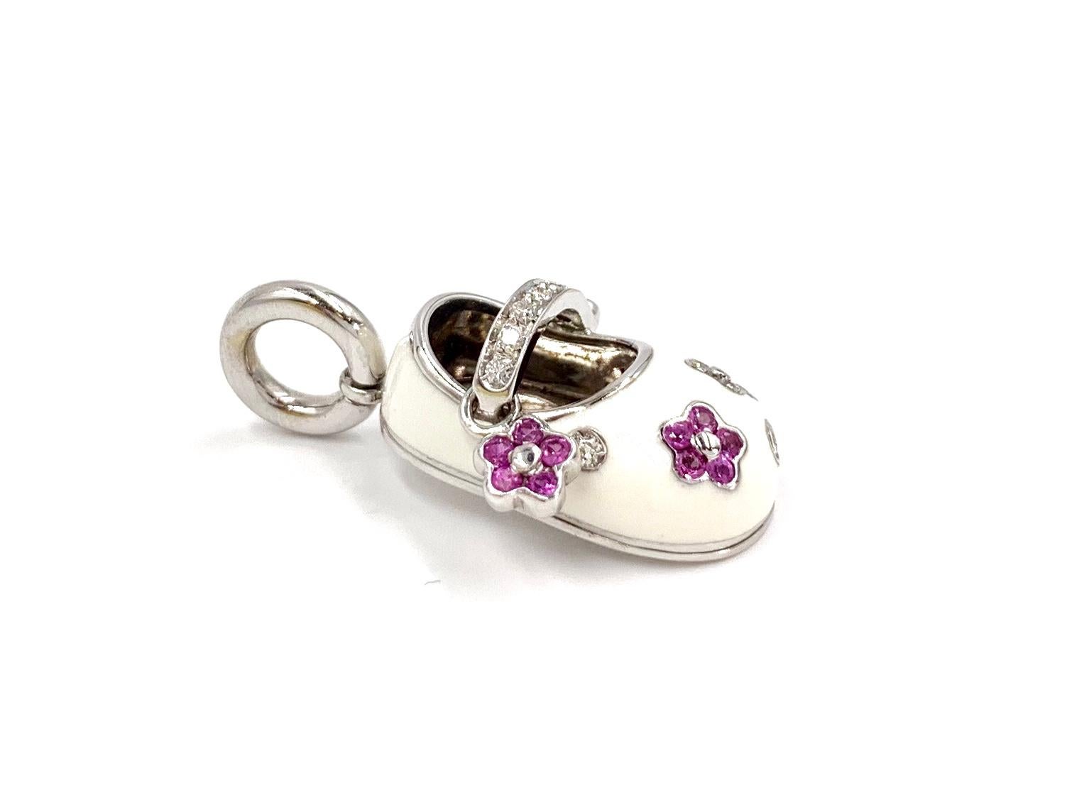 Hand crafted with exceptional quality by high-jewelry designer, Aaron Basha. Known for their adorable yet stylish designs and iconic baby shoe charms. This 18 Karat white gold and white enamel baby girl shoe is adorned with vibrant pink sapphires at